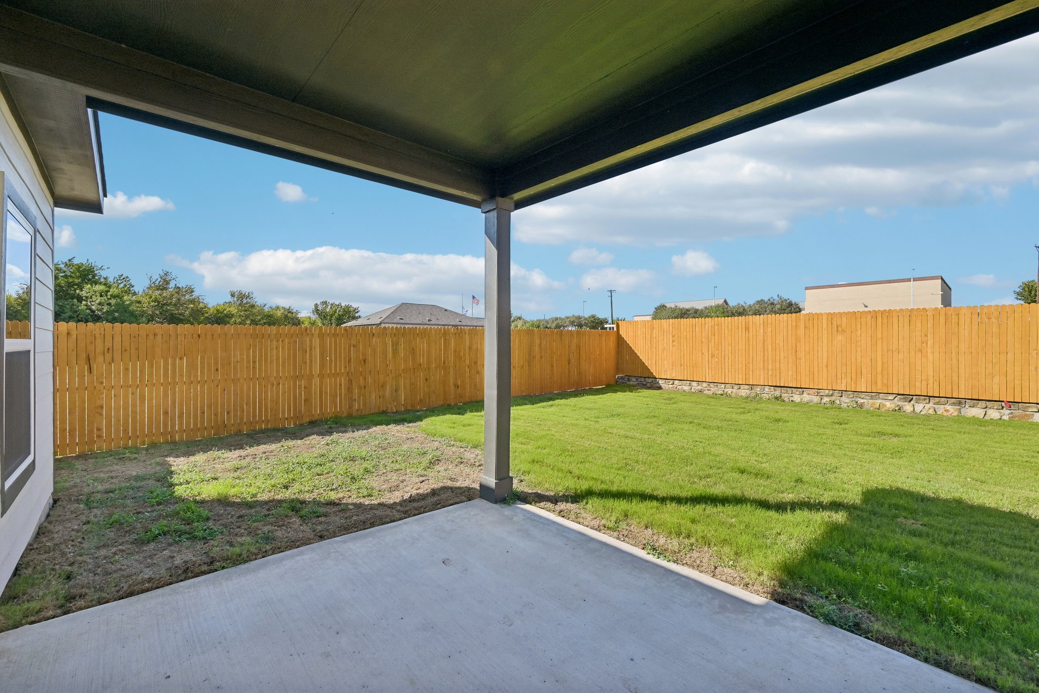 A fenced in yard with a wood fence and a wood fence.