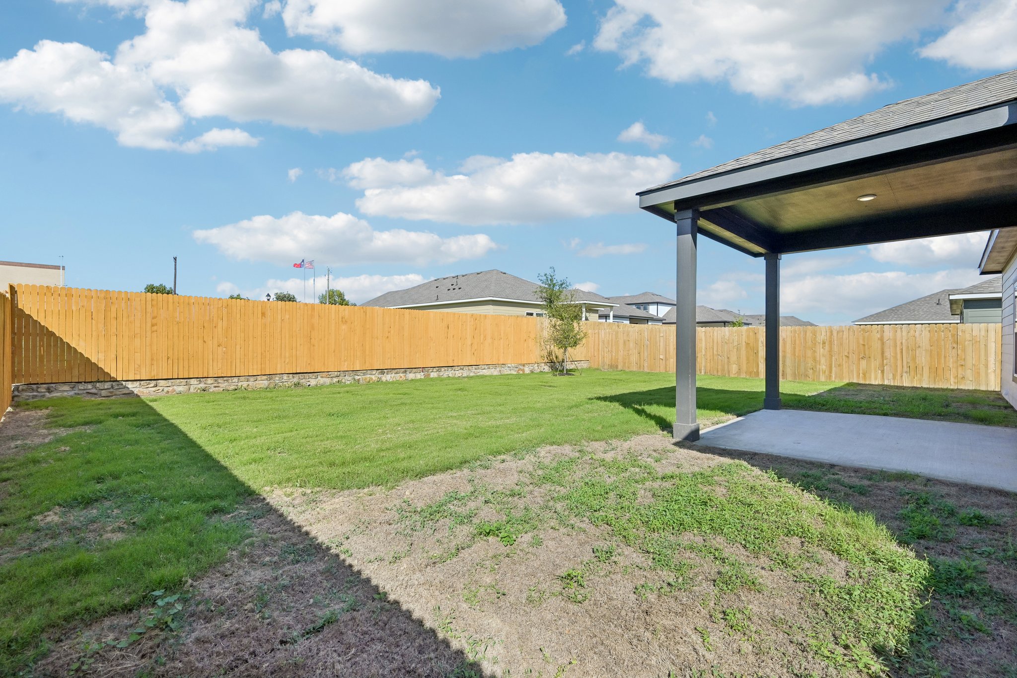 A fenced in yard with a building in the background.