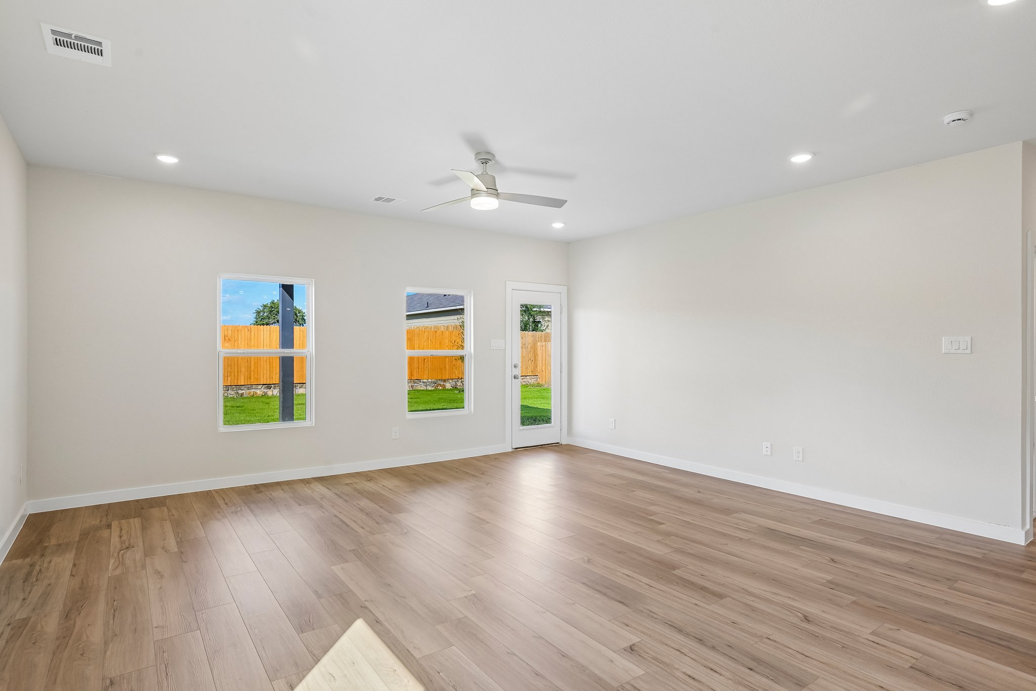 A room with a wood floor and a ceiling fan.
