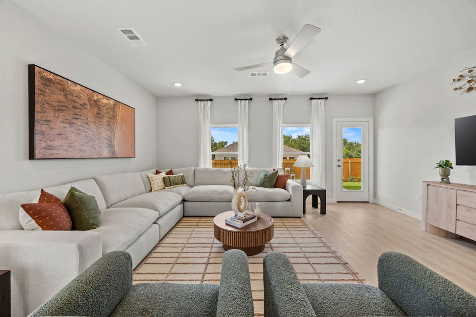 A living room with a large white couch and a large chandelier.
