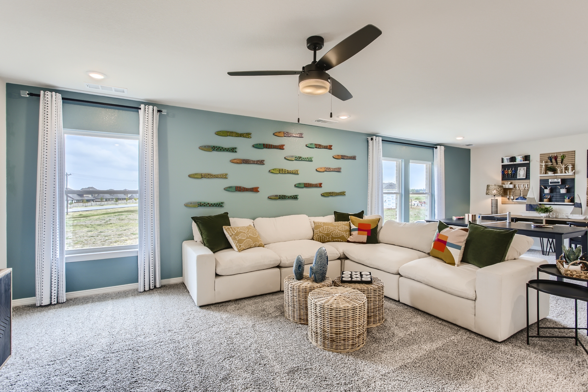A living room with a white couch and a fan.