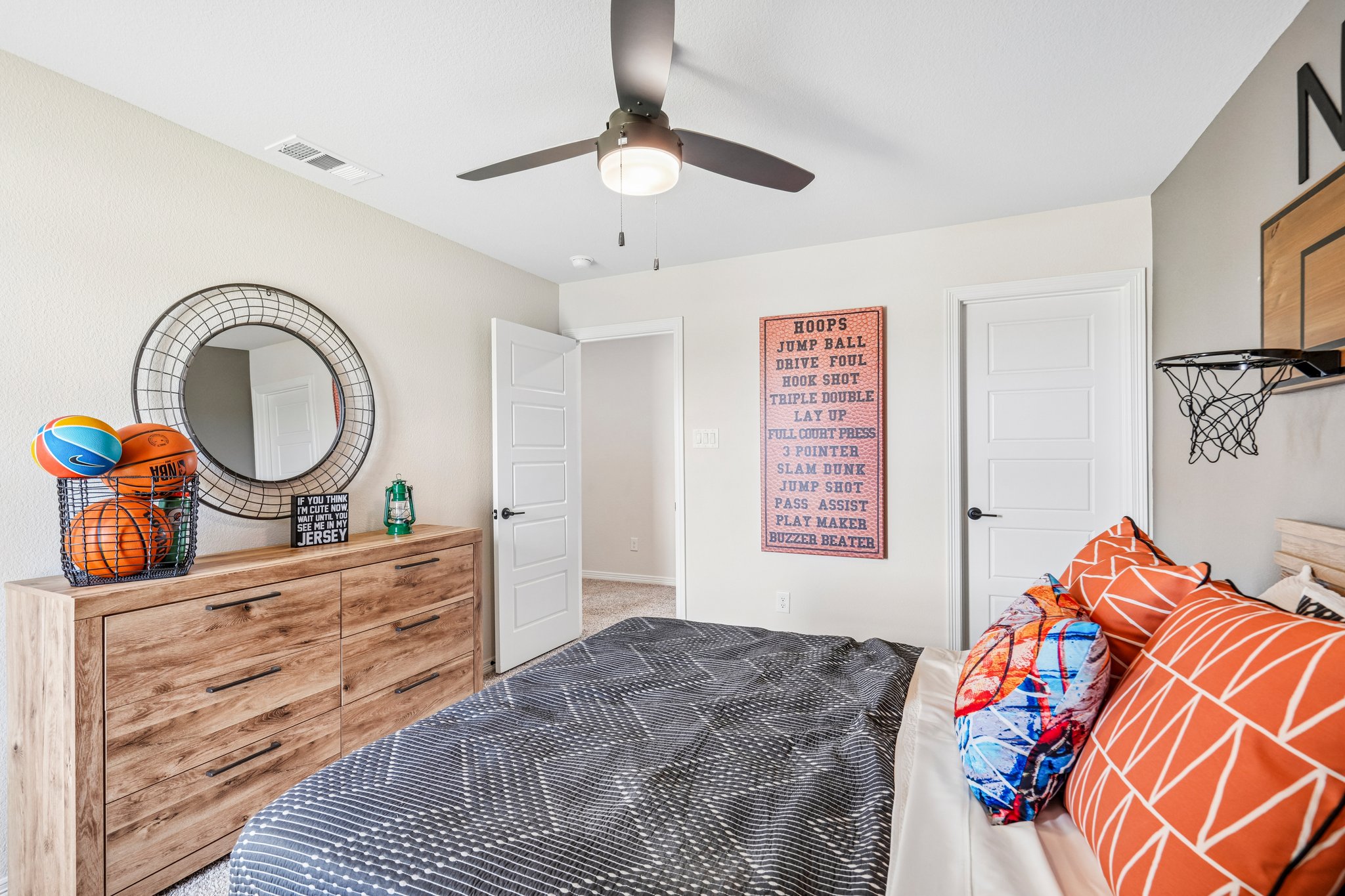 A bedroom with a bed and a mirror.