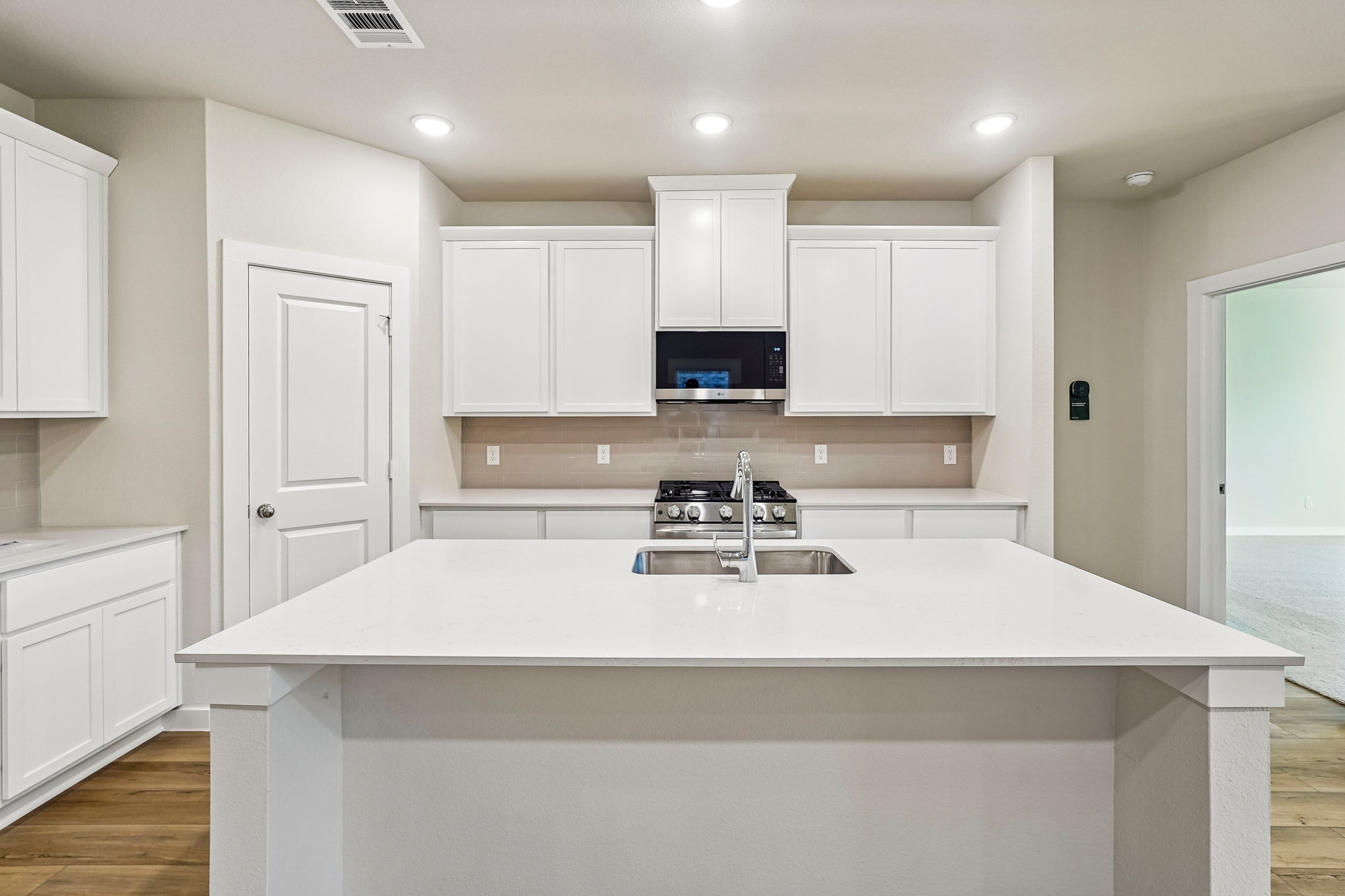 A kitchen with white cabinets.