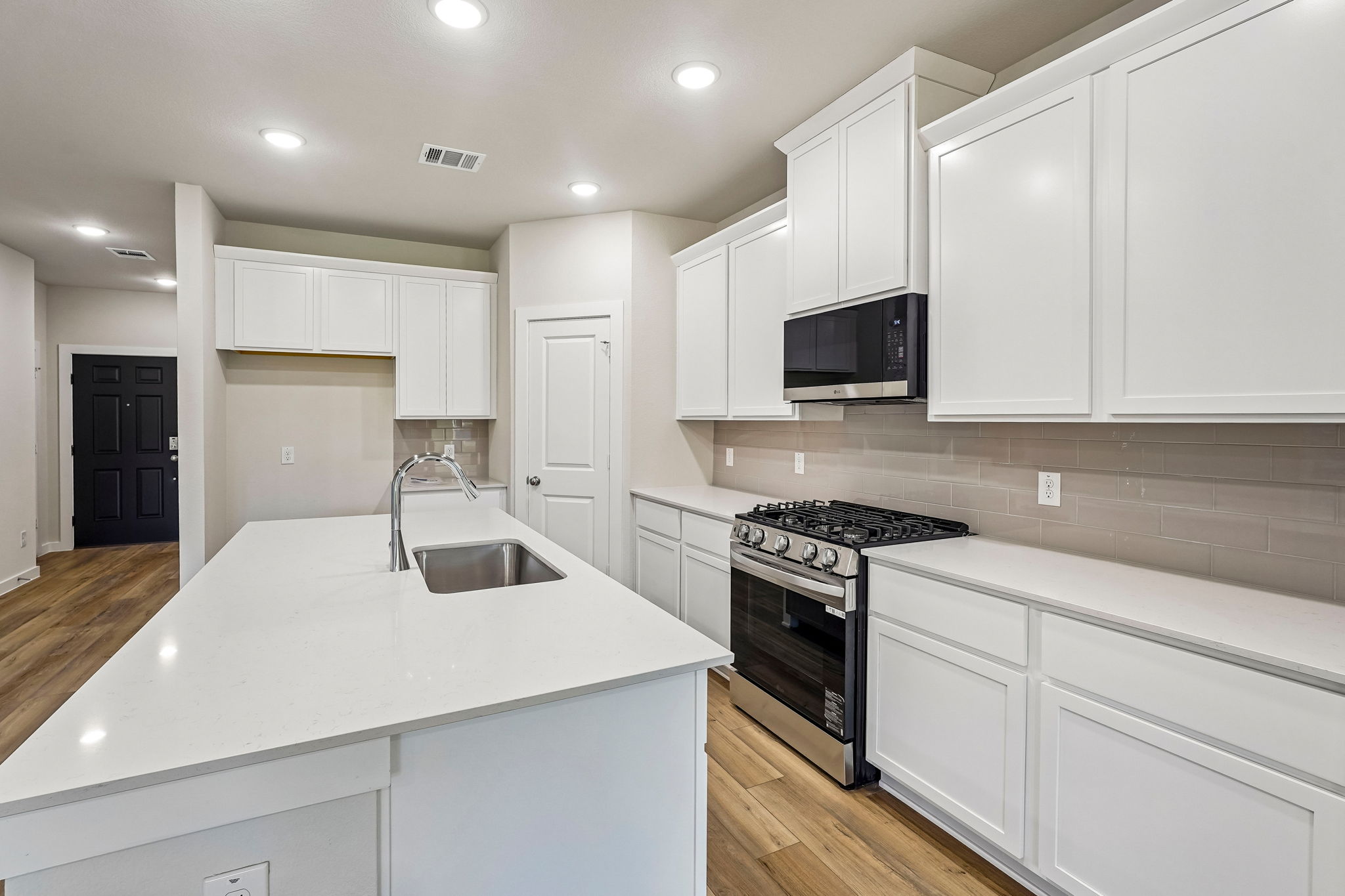 A kitchen with white cabinets.