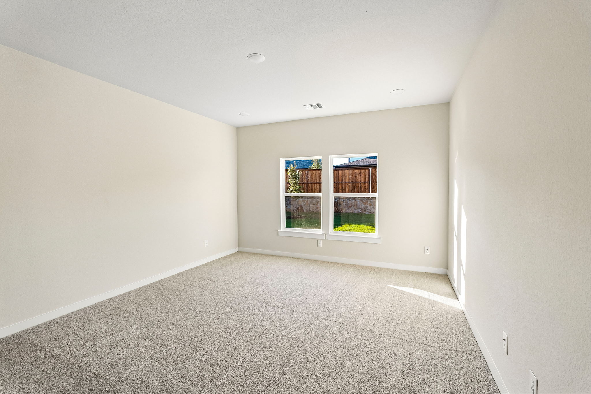 A room with a window and carpet.