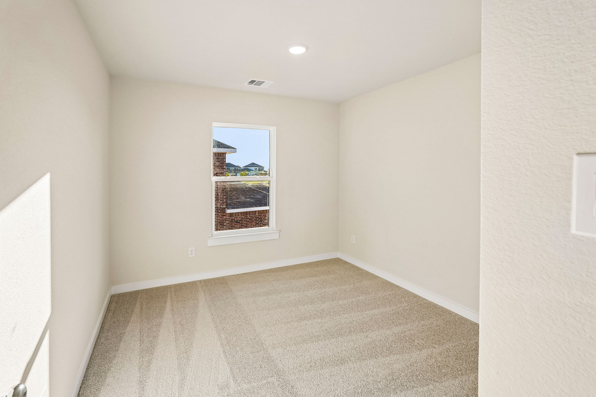 A room with a window and a rug.