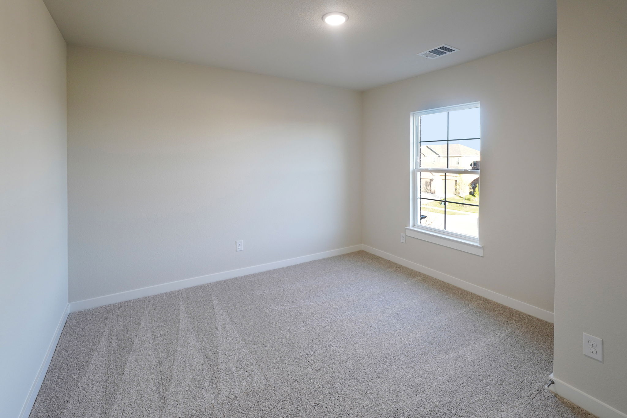 A room with a window and a carpet.