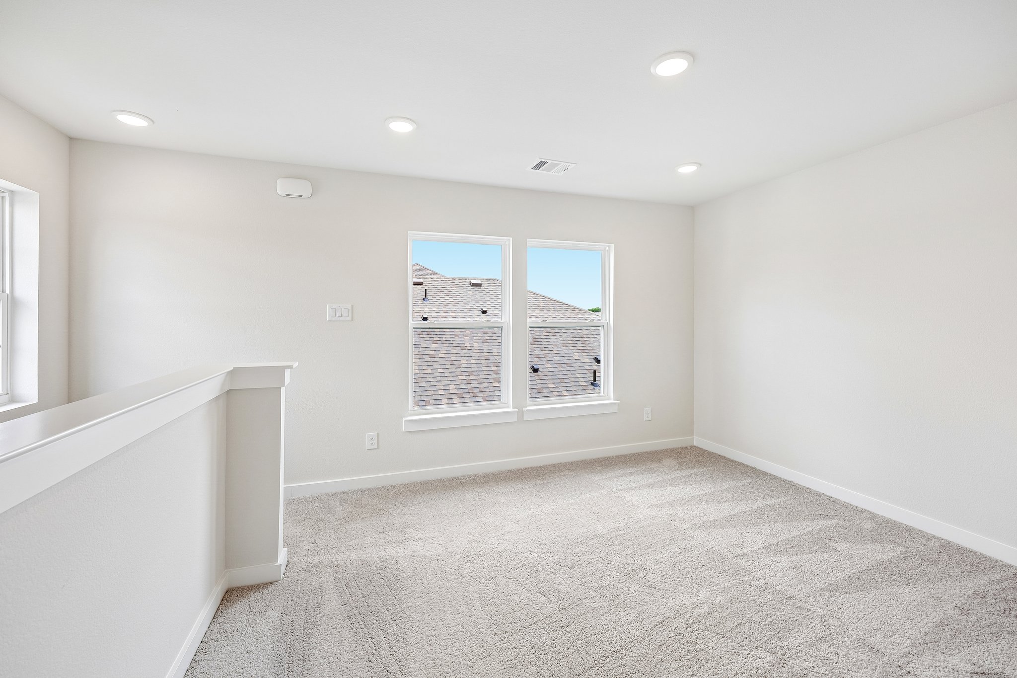 A room with a window and a white wall with a window.