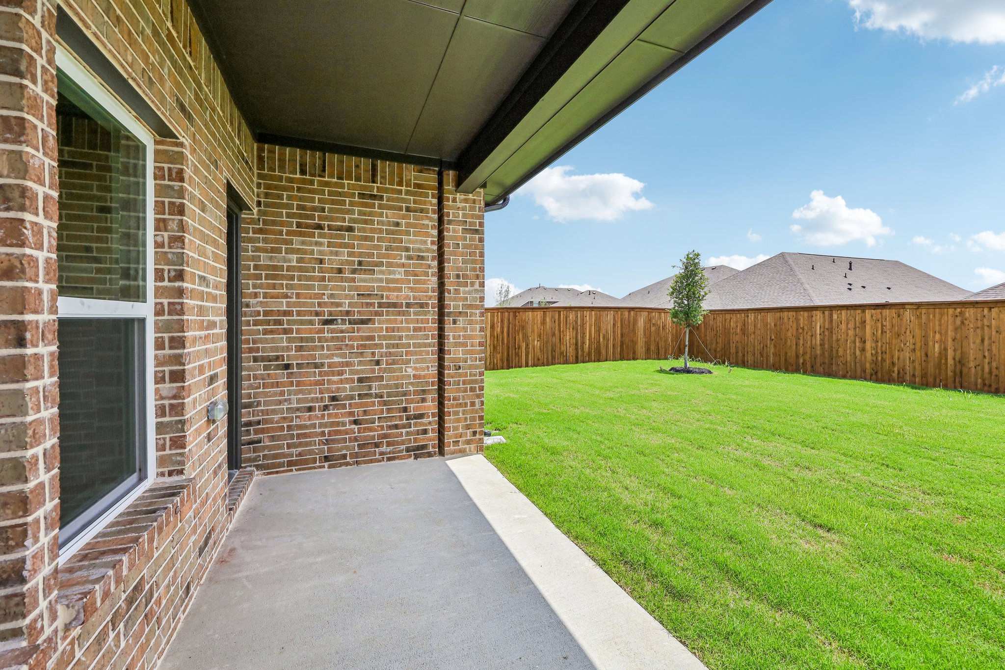 A brick building with a fence and grass.