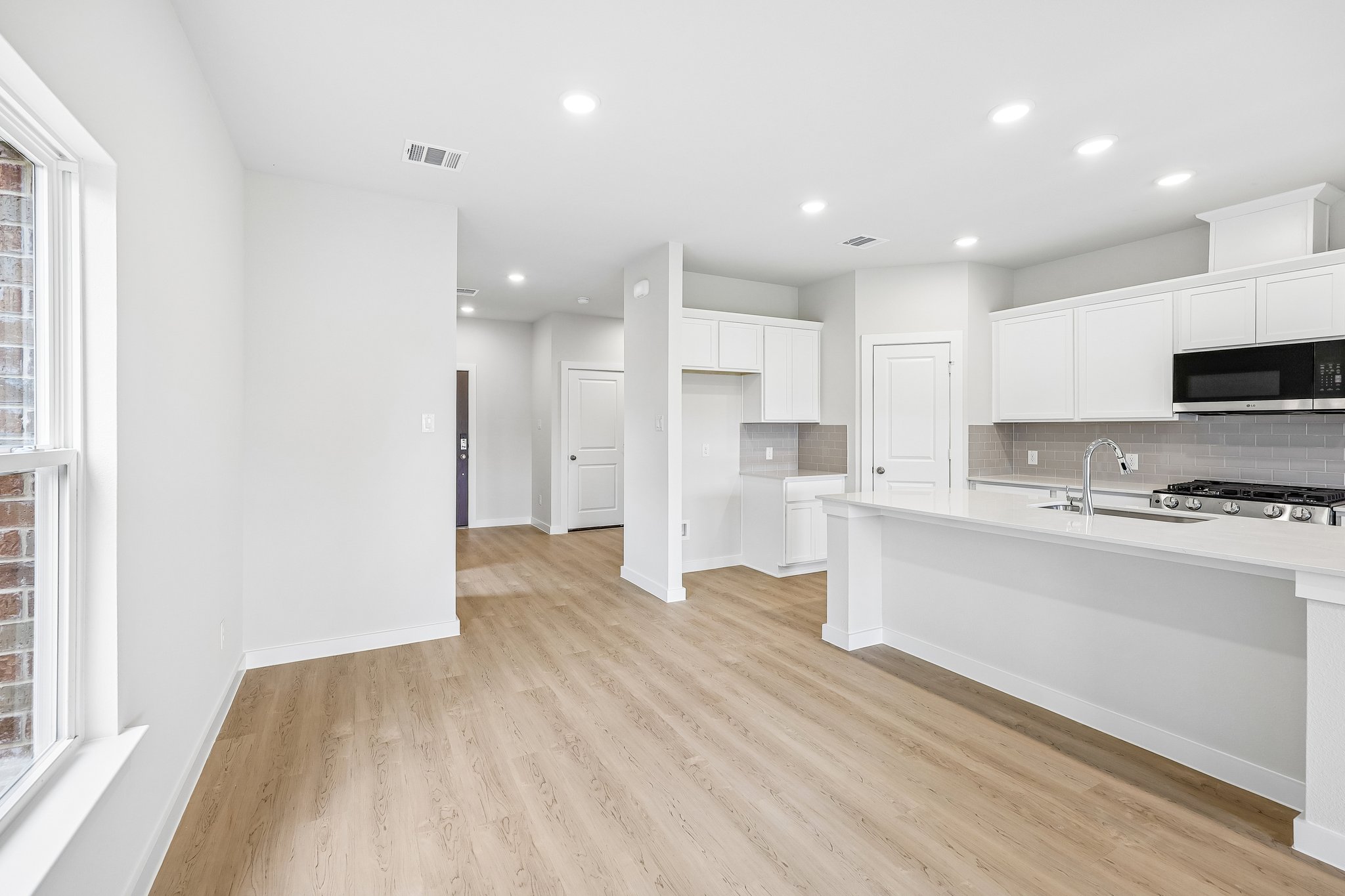 A kitchen with white cabinets.
