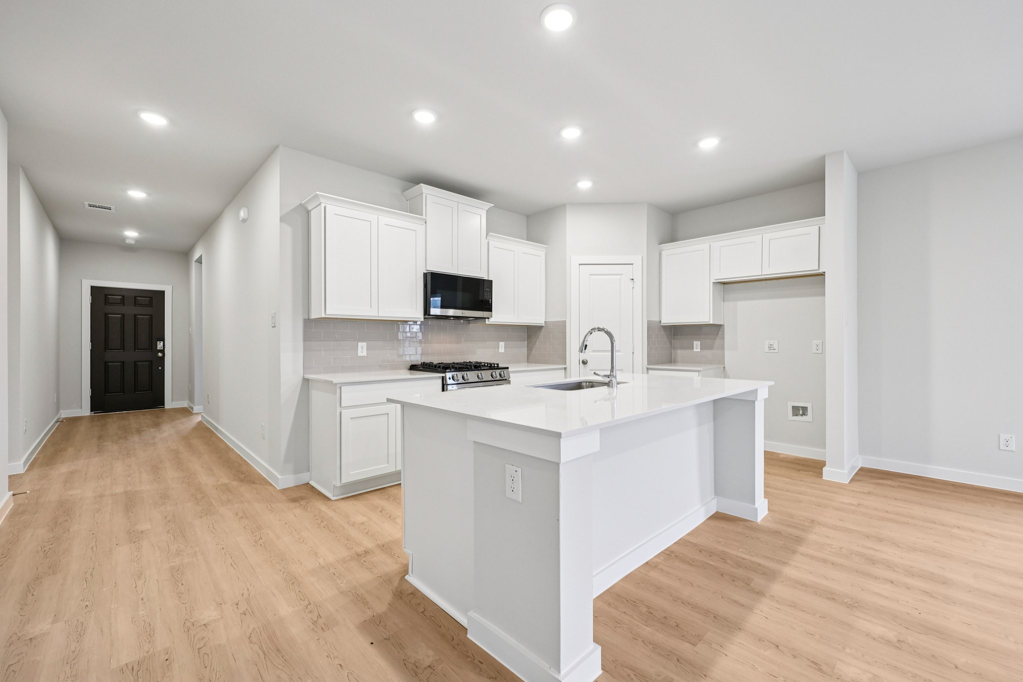 A kitchen with white cabinets.