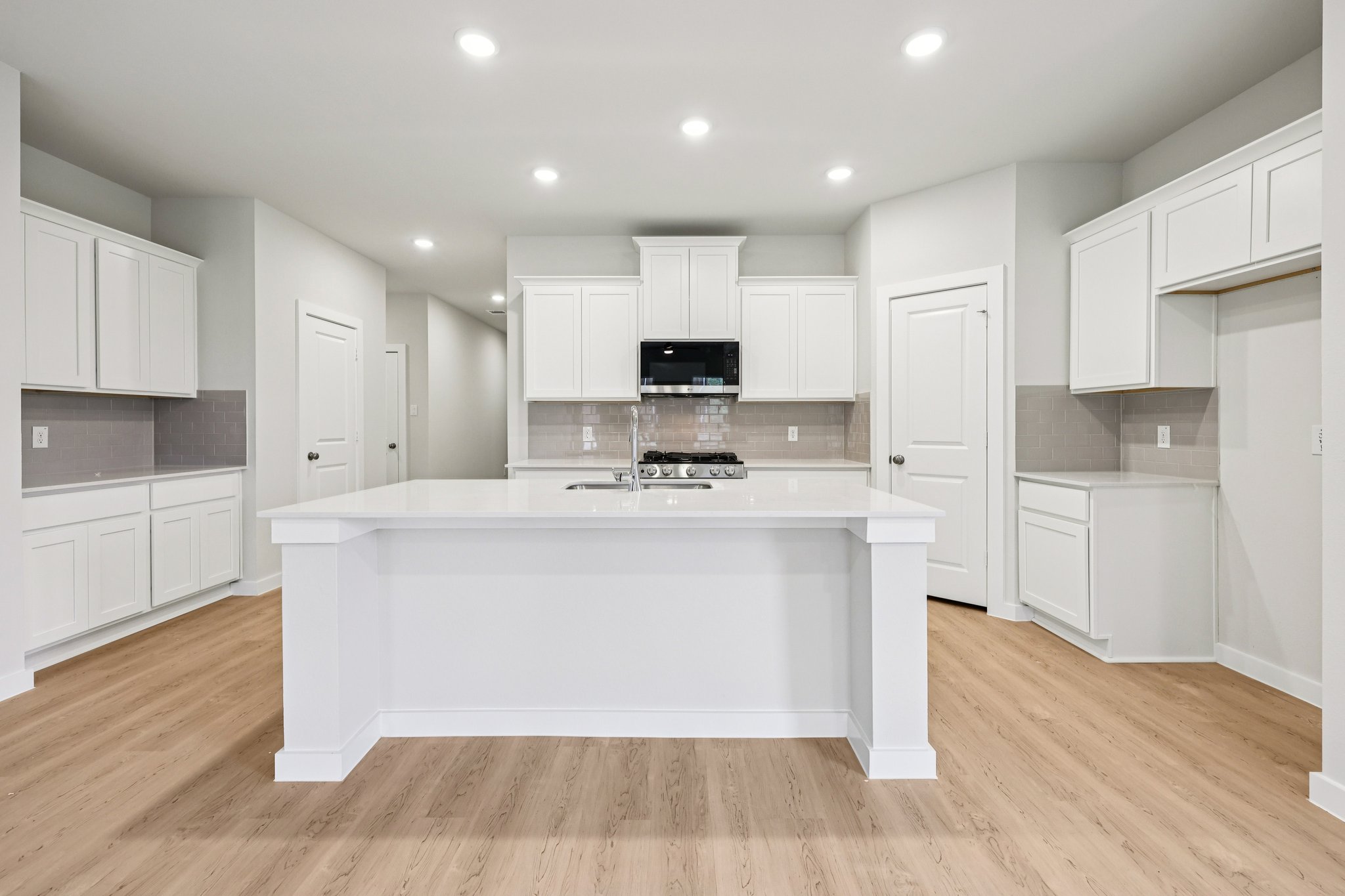 A kitchen with white cabinets.