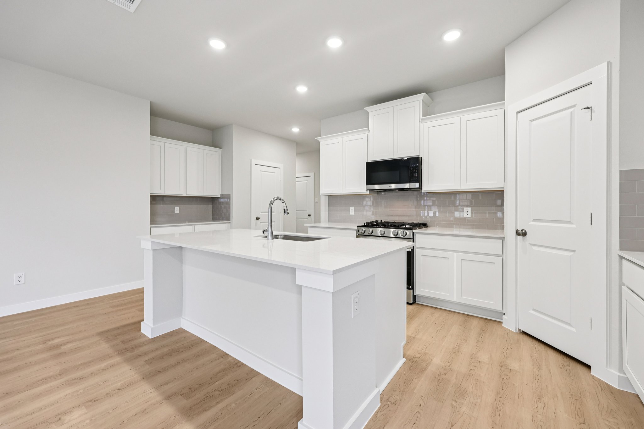 A kitchen with white cabinets.