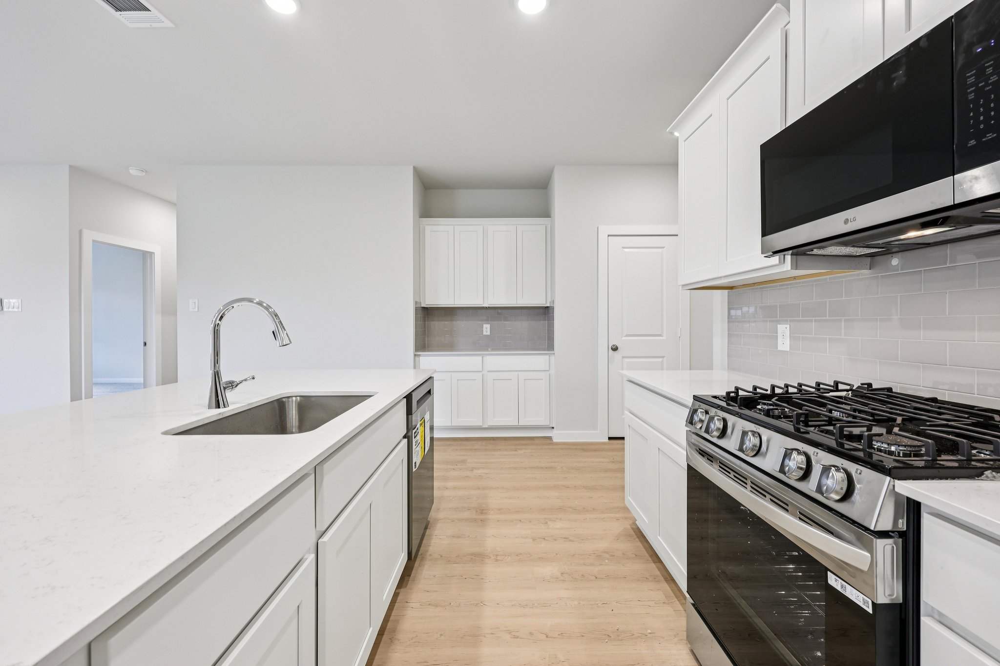 A kitchen with white cabinets.