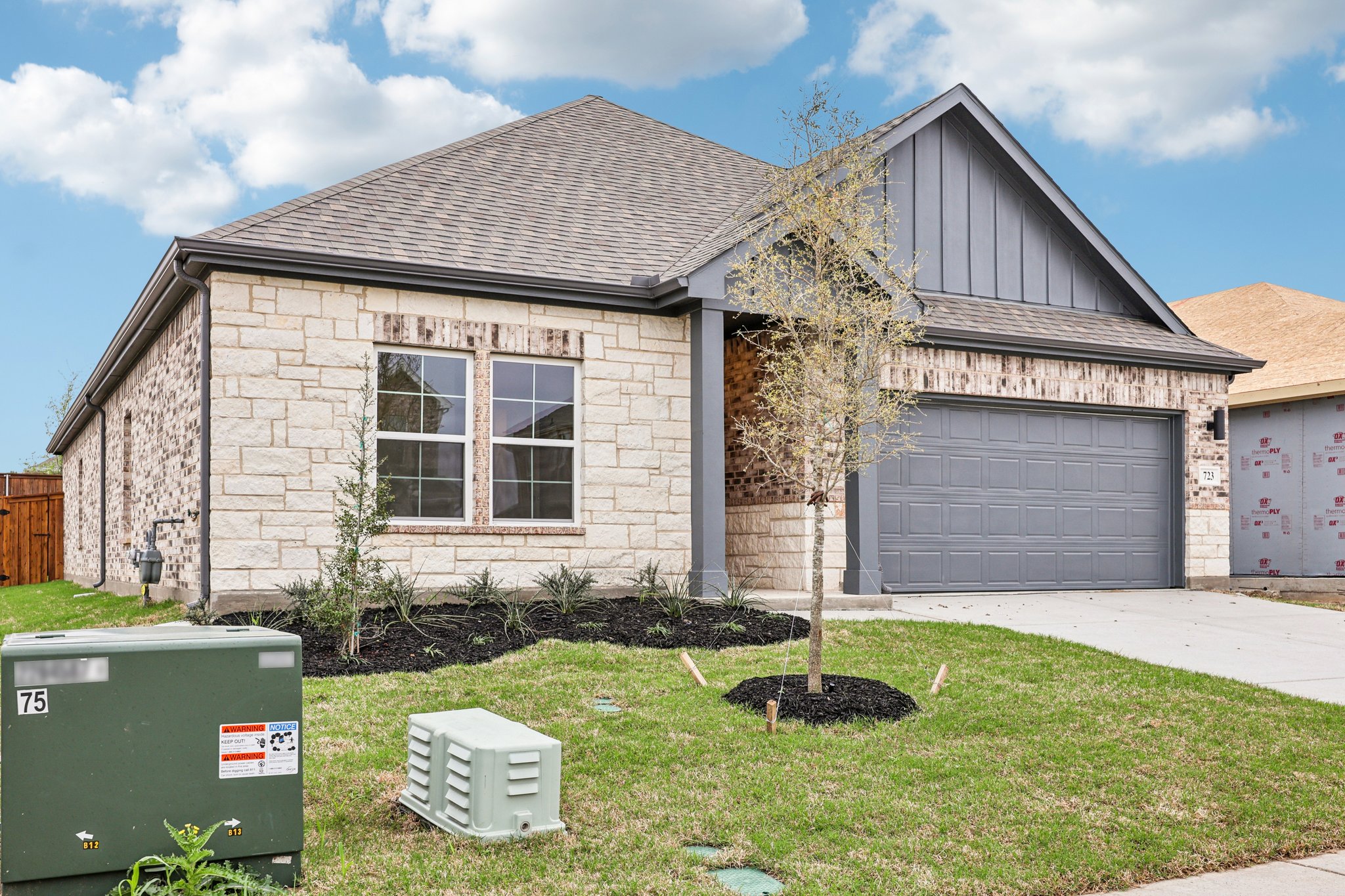 A house with a tree in the front yard.