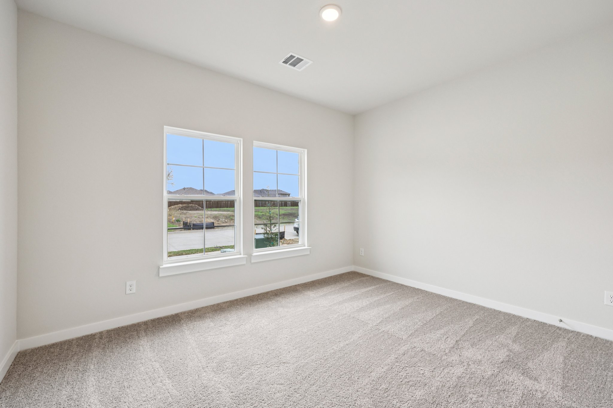 A room with a window and a white wall.