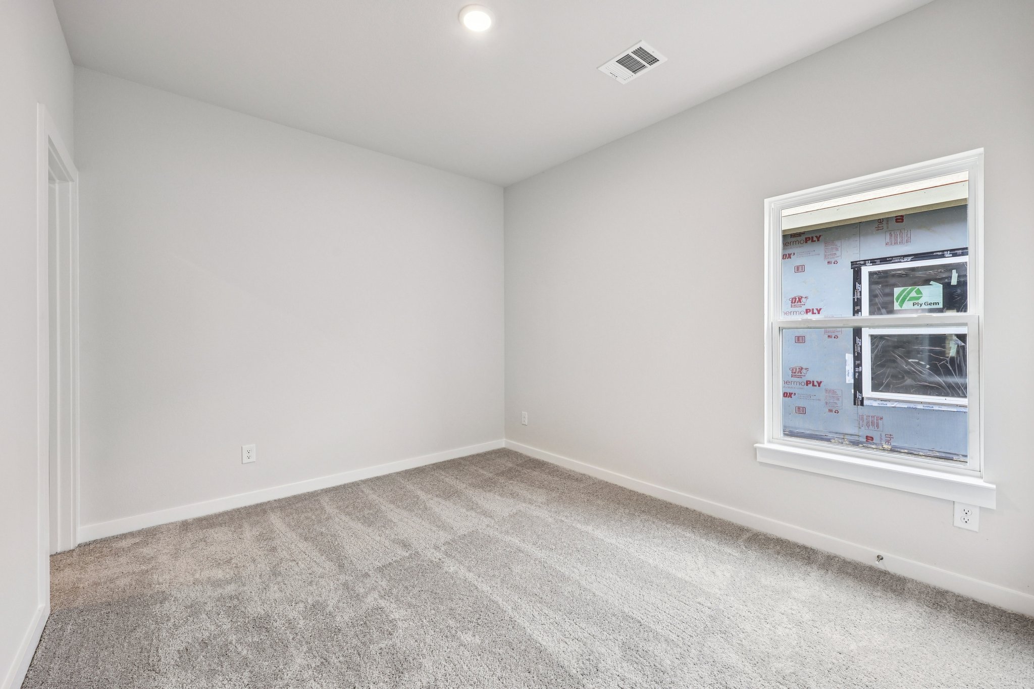 A room with a window and a carpet.