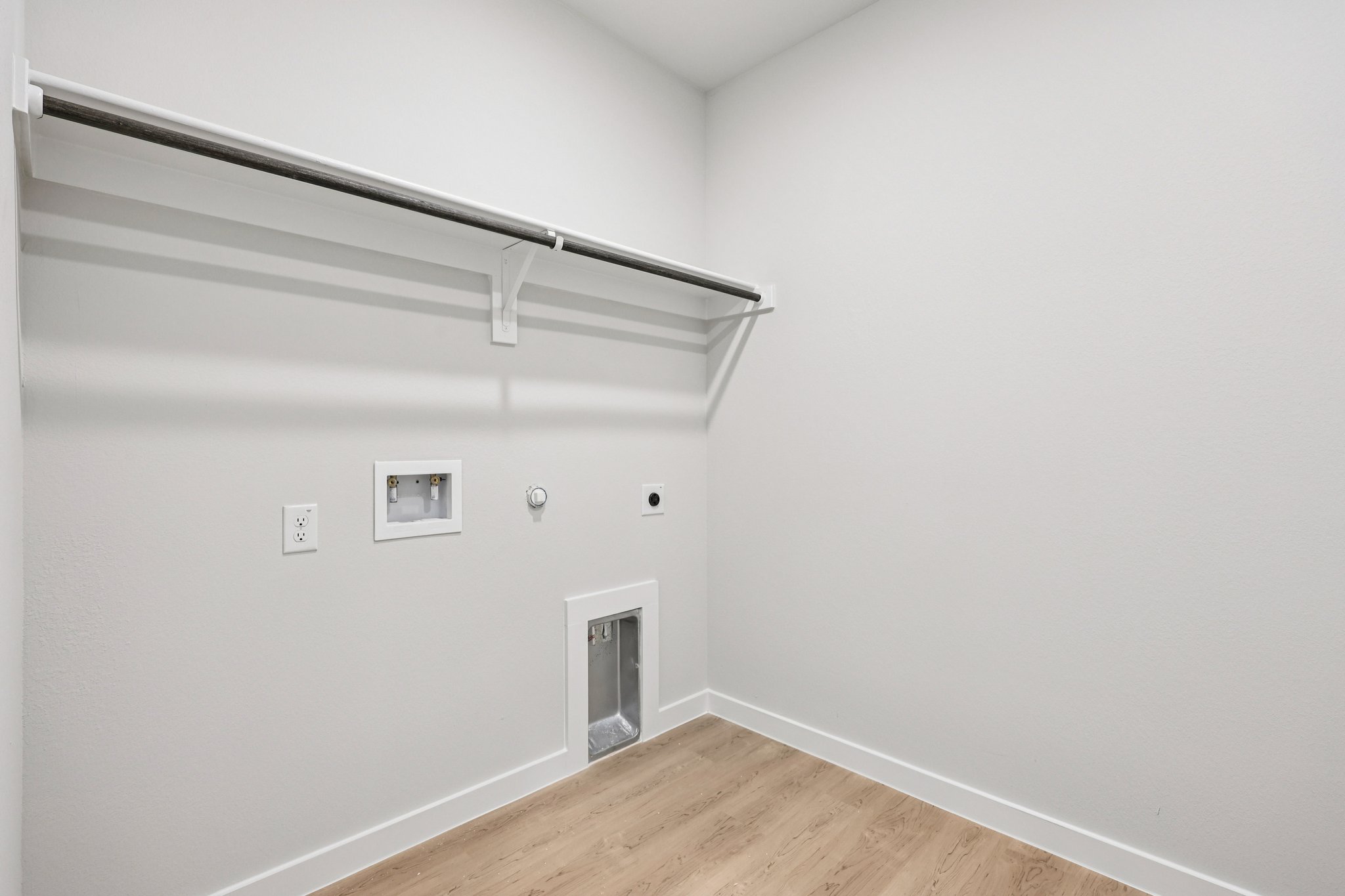 A white wall with a wood floor.