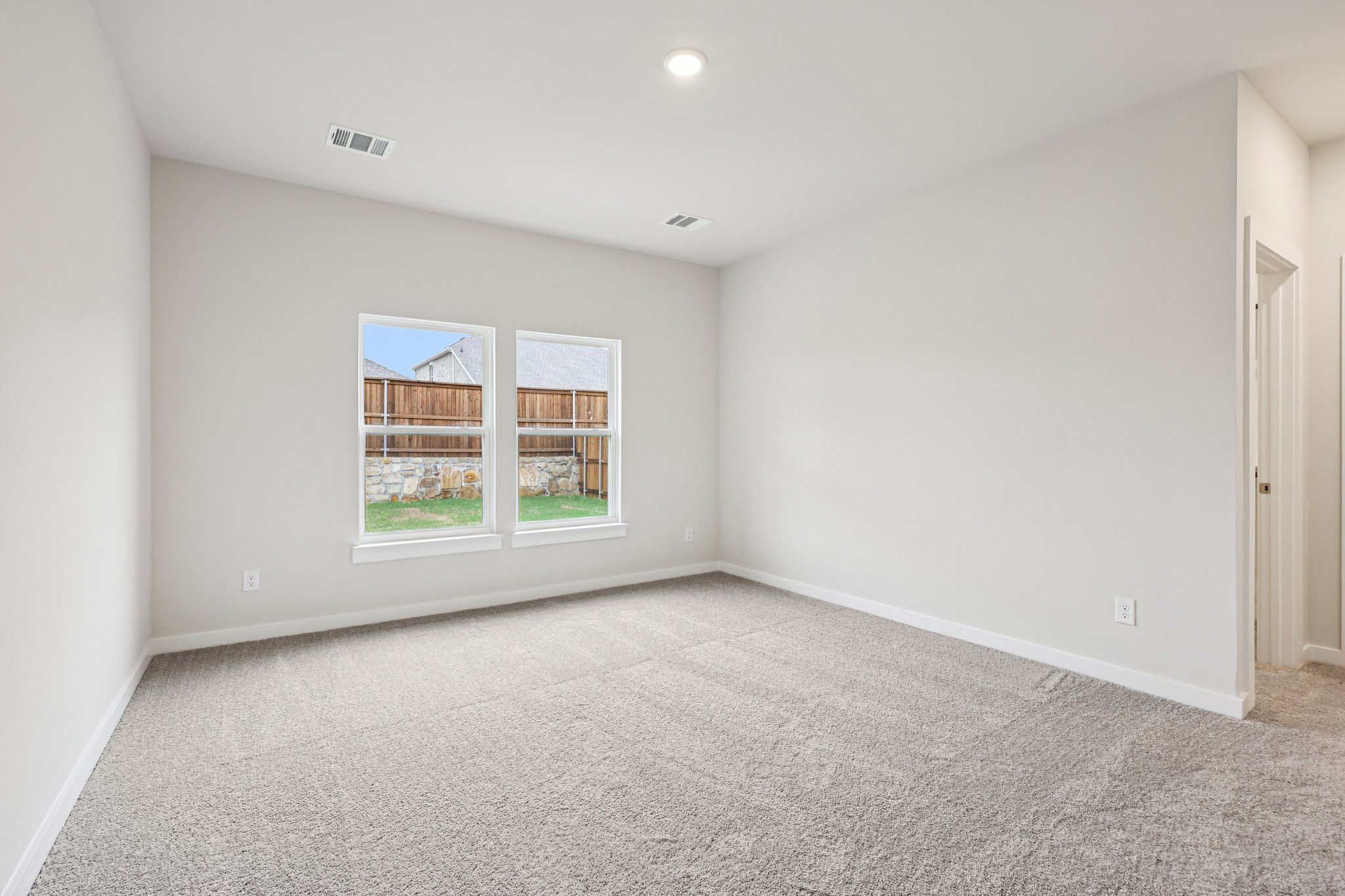 A room with a window and a carpet.