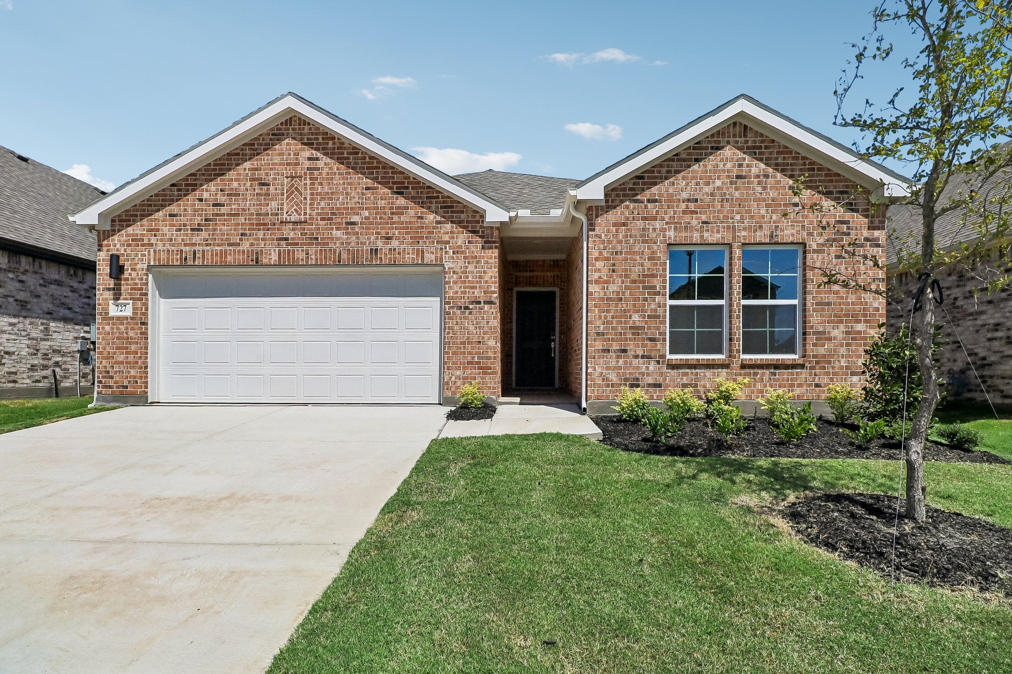 A brick house with a garage.