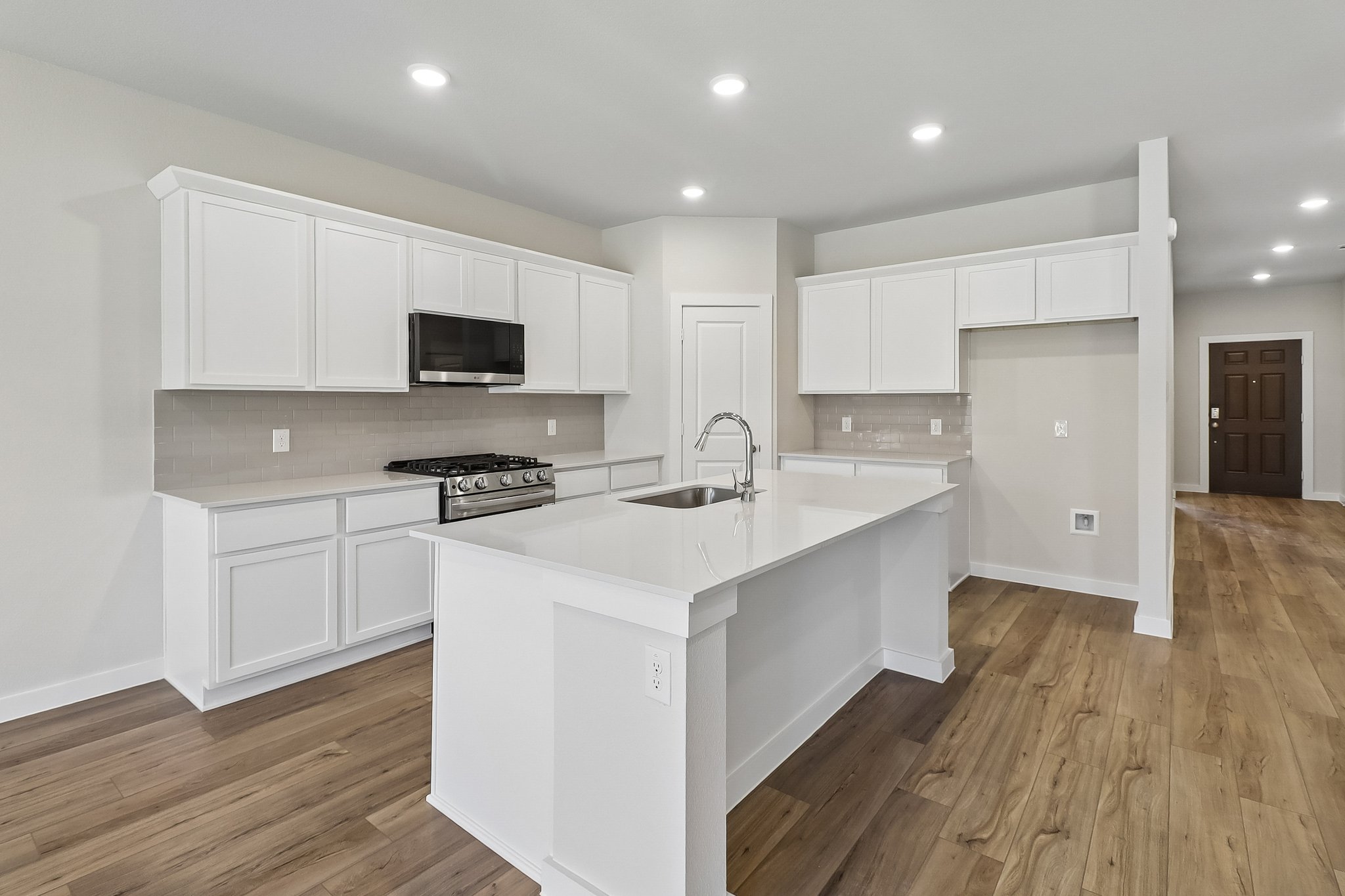 A kitchen with white cabinets.