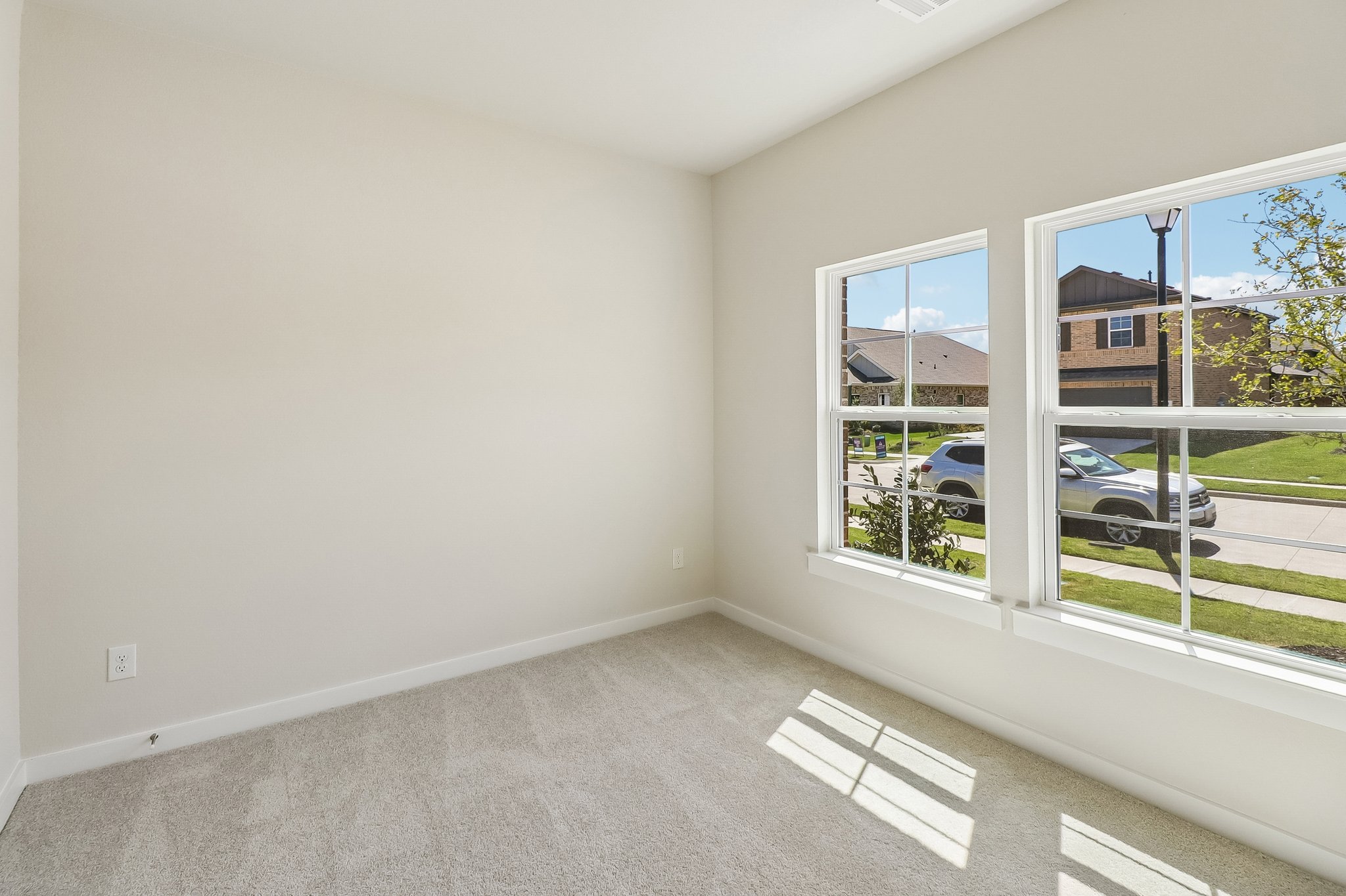A room with a window and a car outside.
