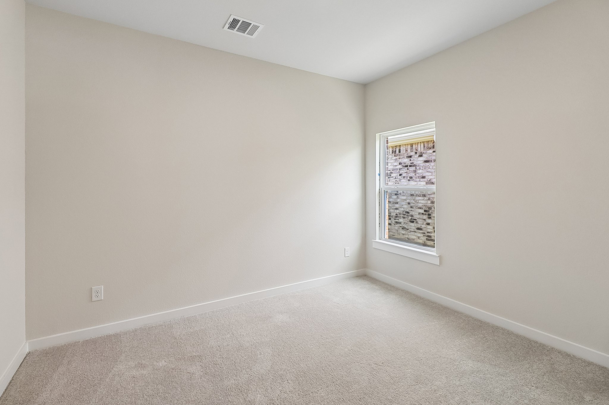 A room with a carpet and a window.