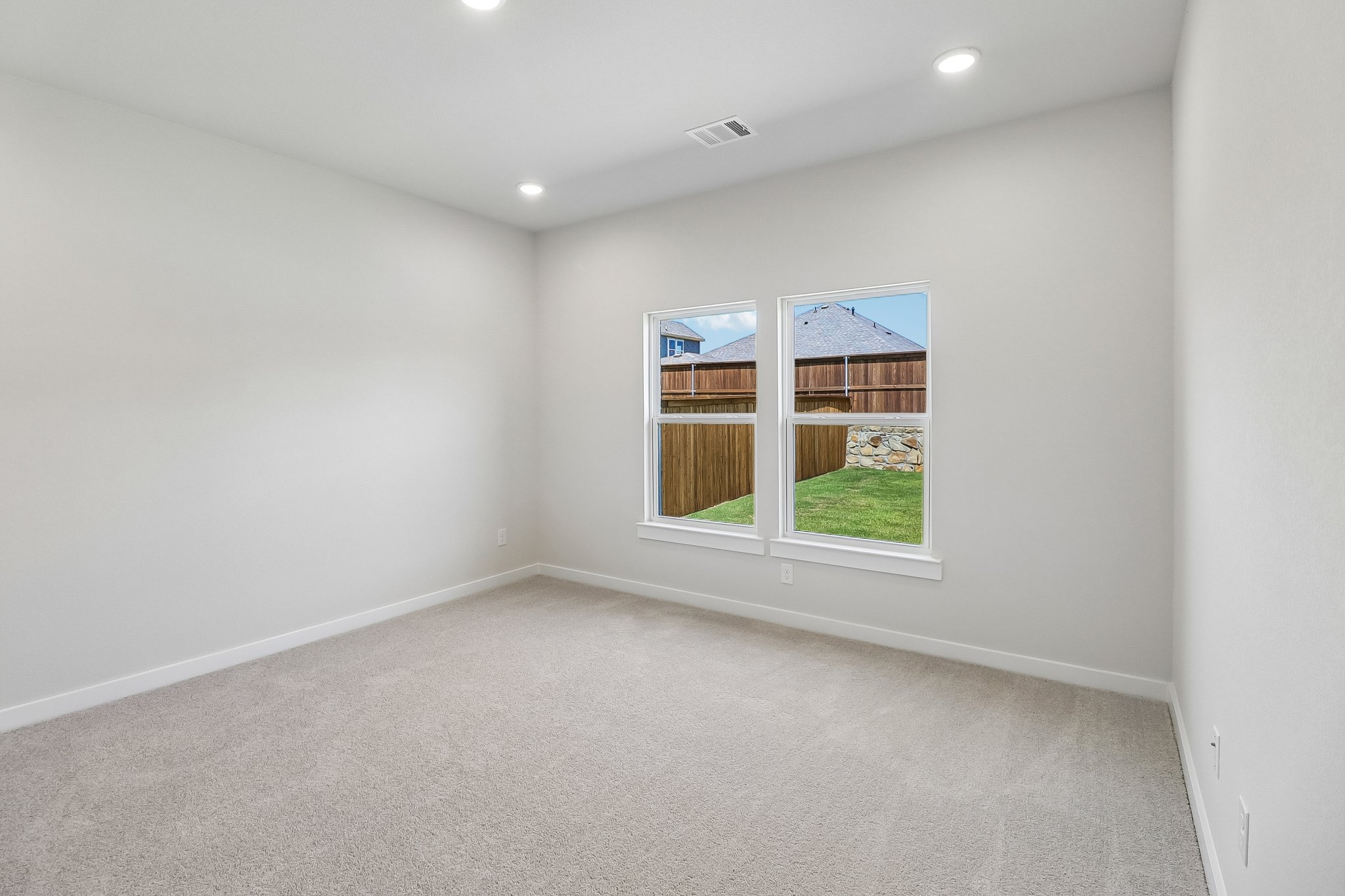 A room with a window and a carpet.