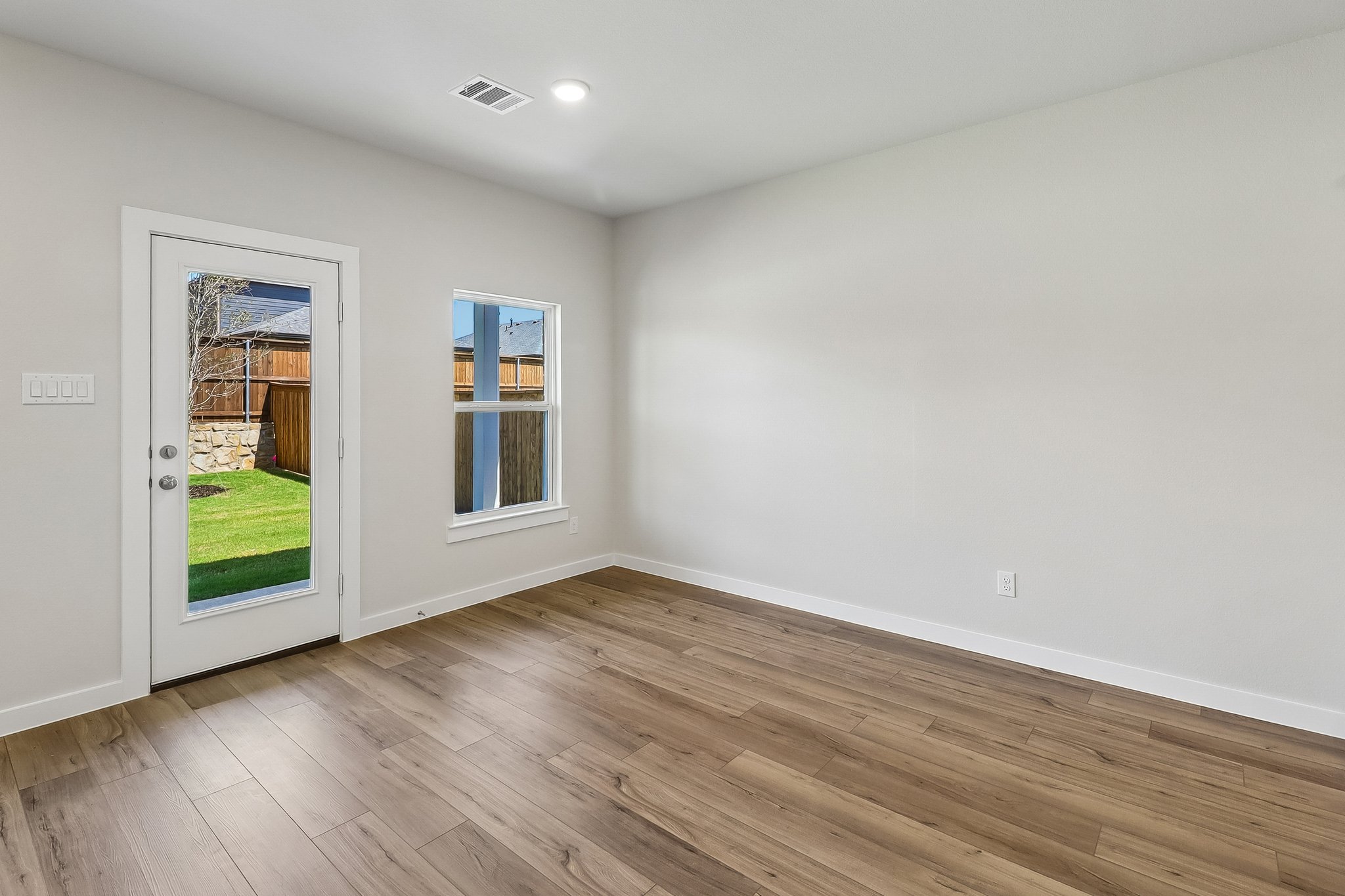 A room with a wood floor and a window.