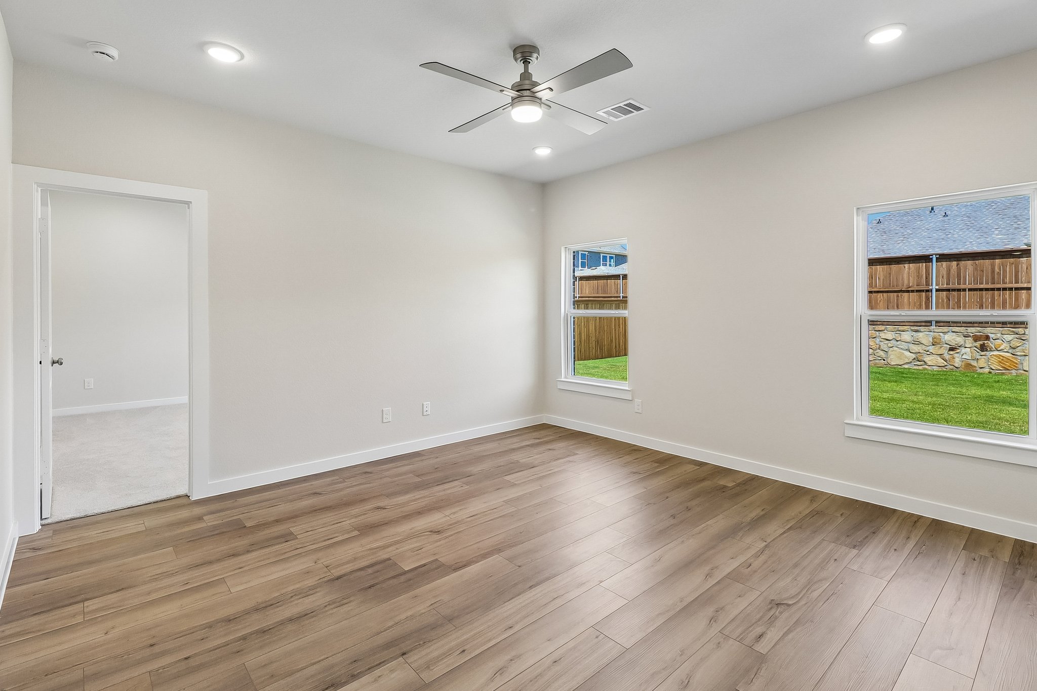 A room with a wood floor and a ceiling fan.