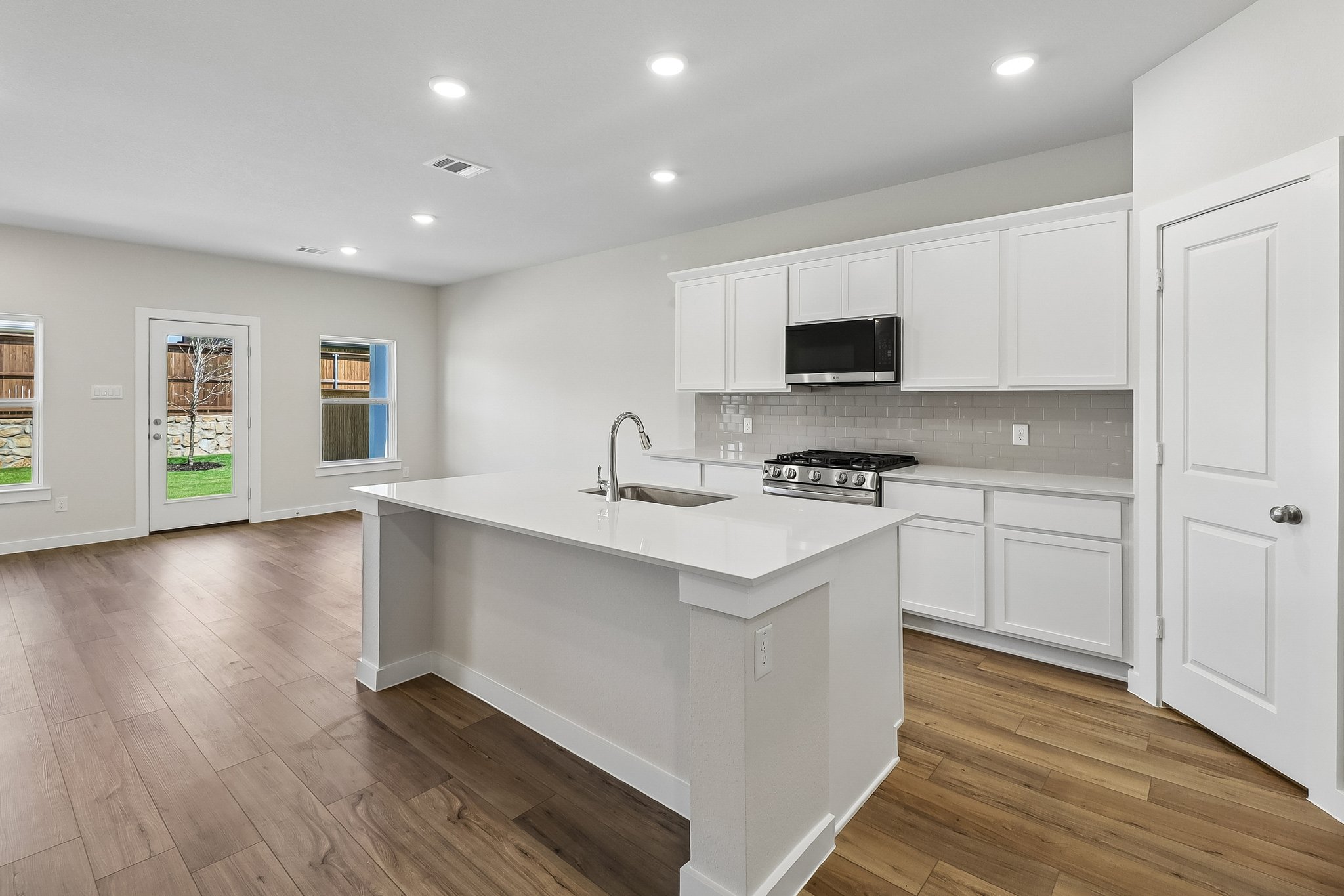 A kitchen with white cabinets.