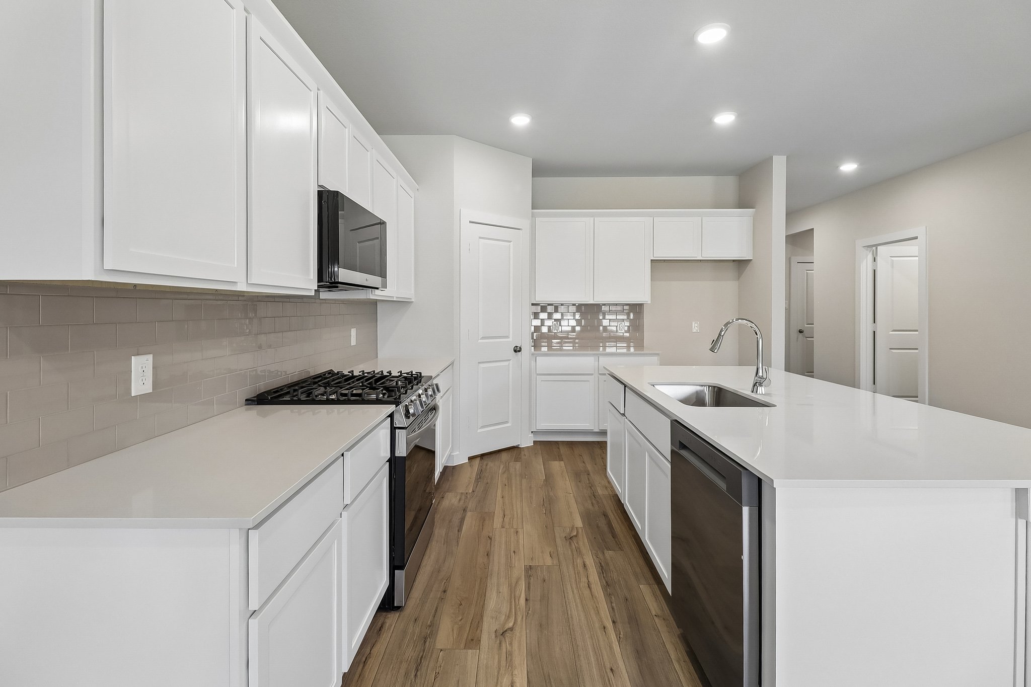 A kitchen with white cabinets.