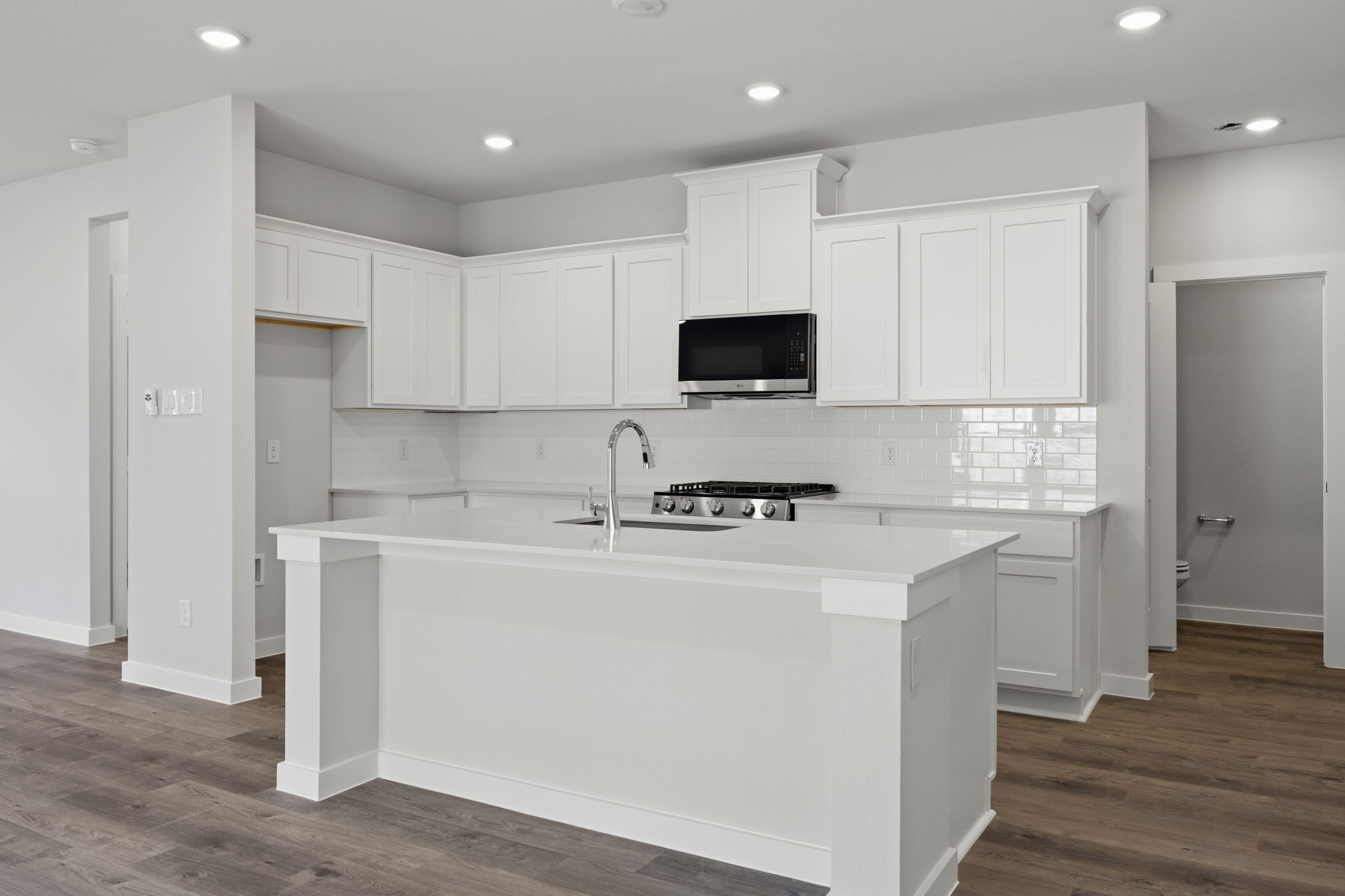 A kitchen with white cabinets.