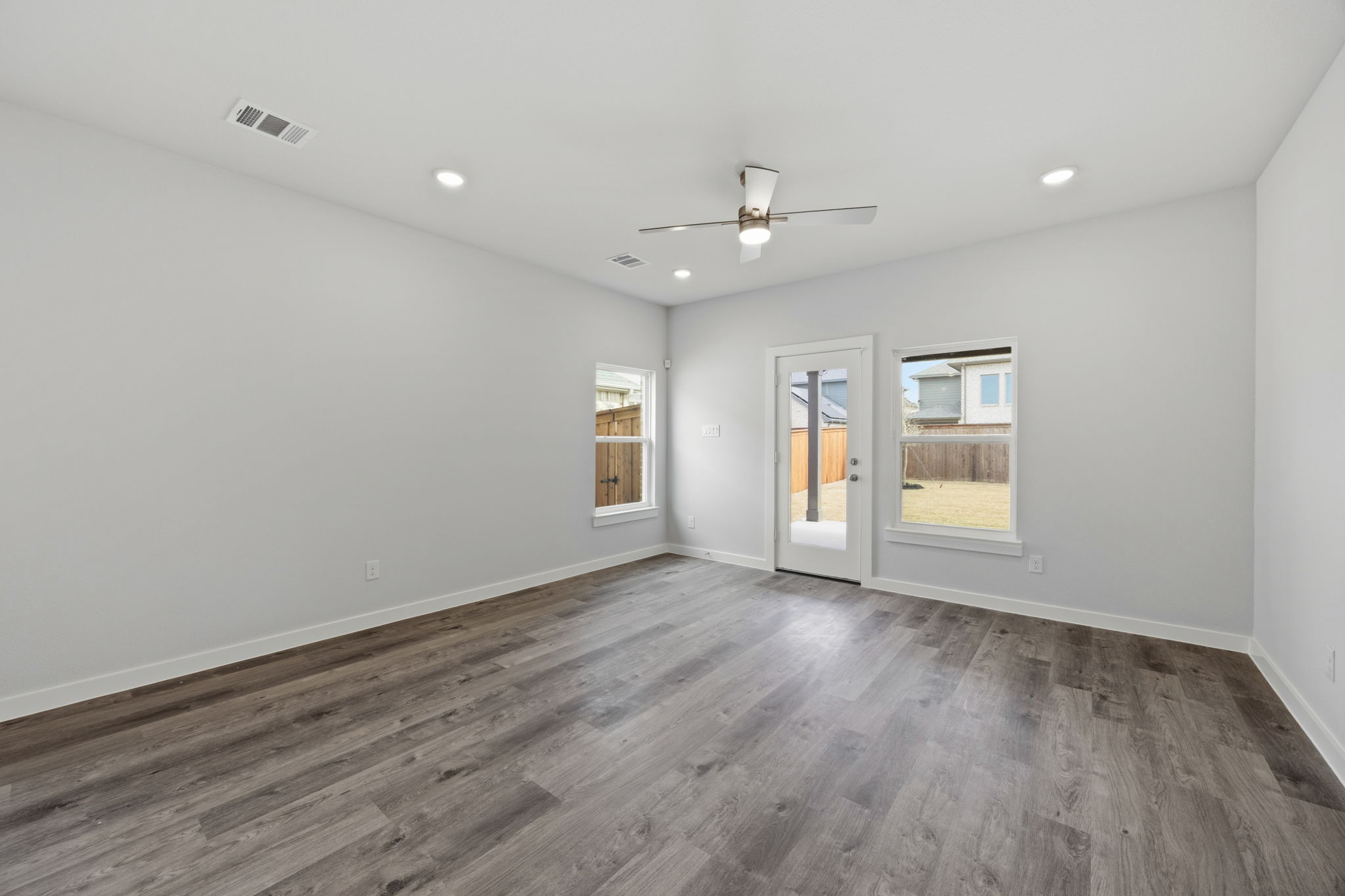 A room with a wood floor and a wood floor with a light on.