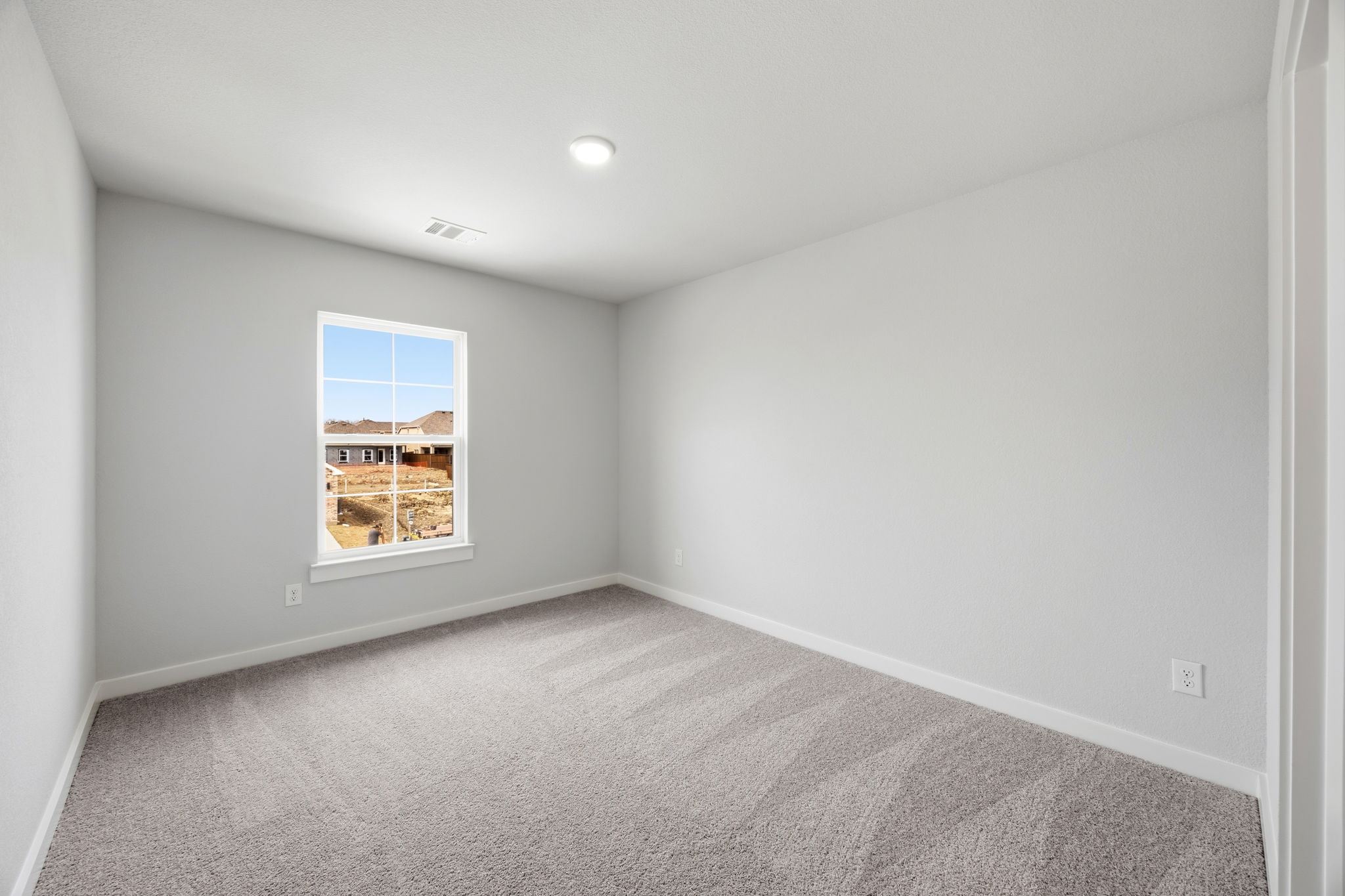 A room with a window and carpet.