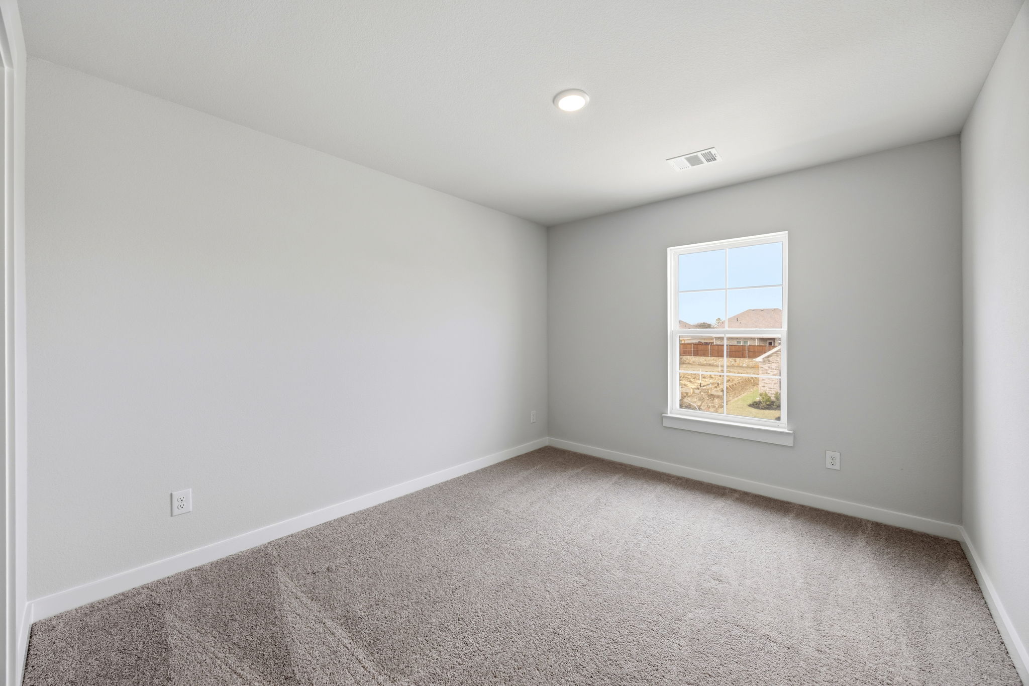 A room with a window and a carpet.