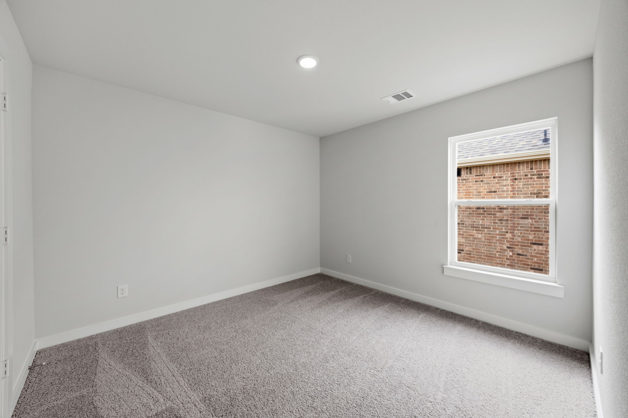 A room with a window and a carpet.