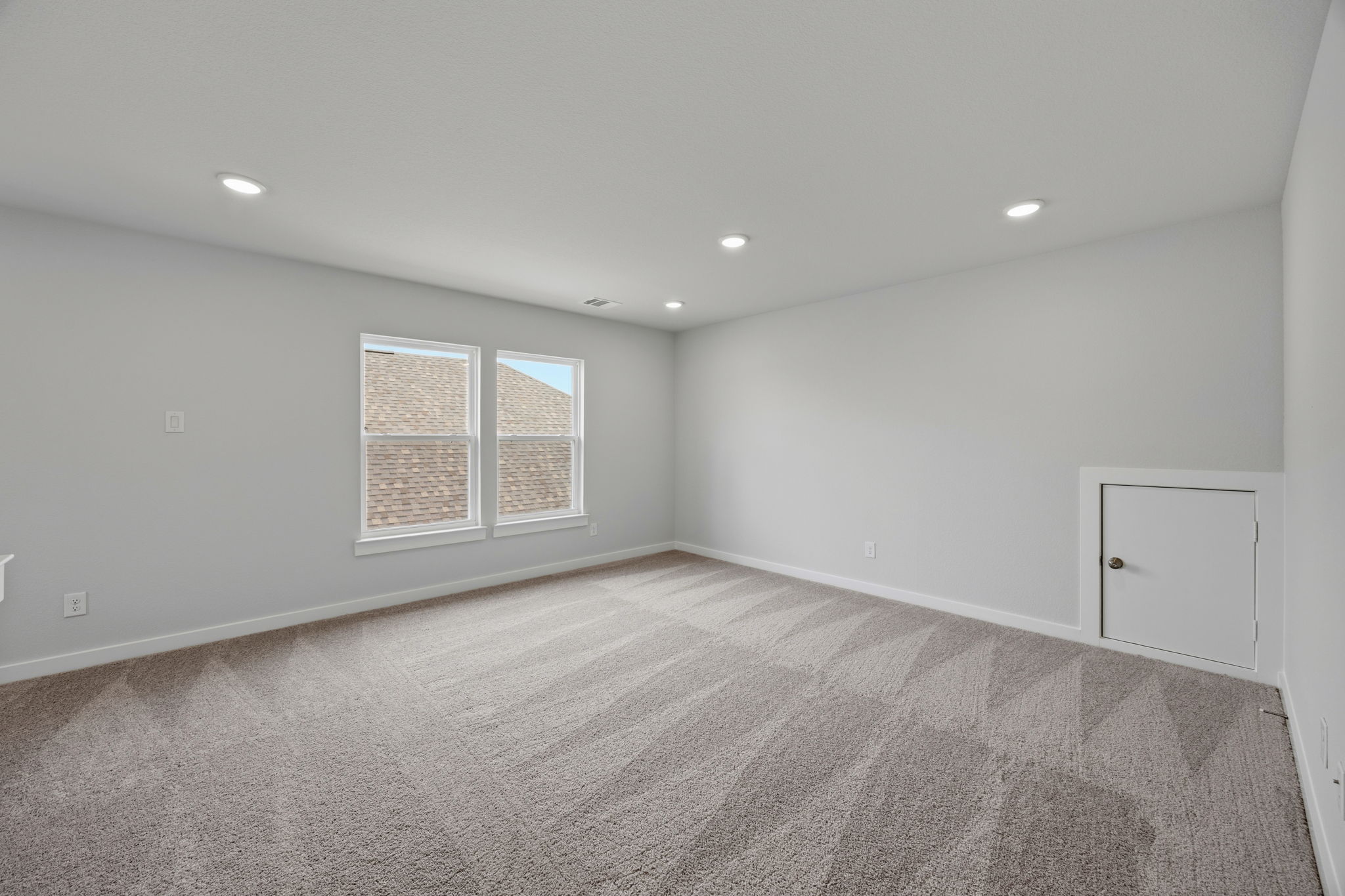 A room with a carpet and a door.