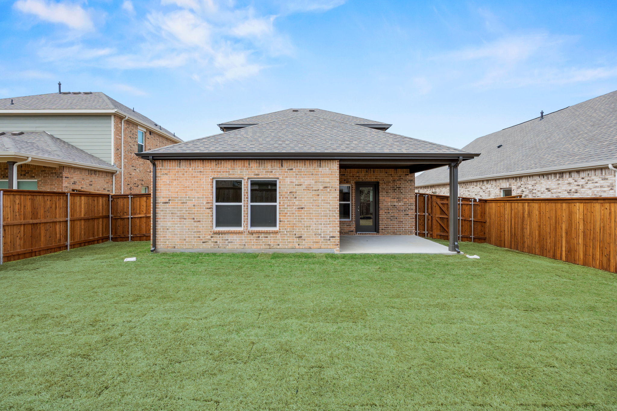A house with a fence and grass.