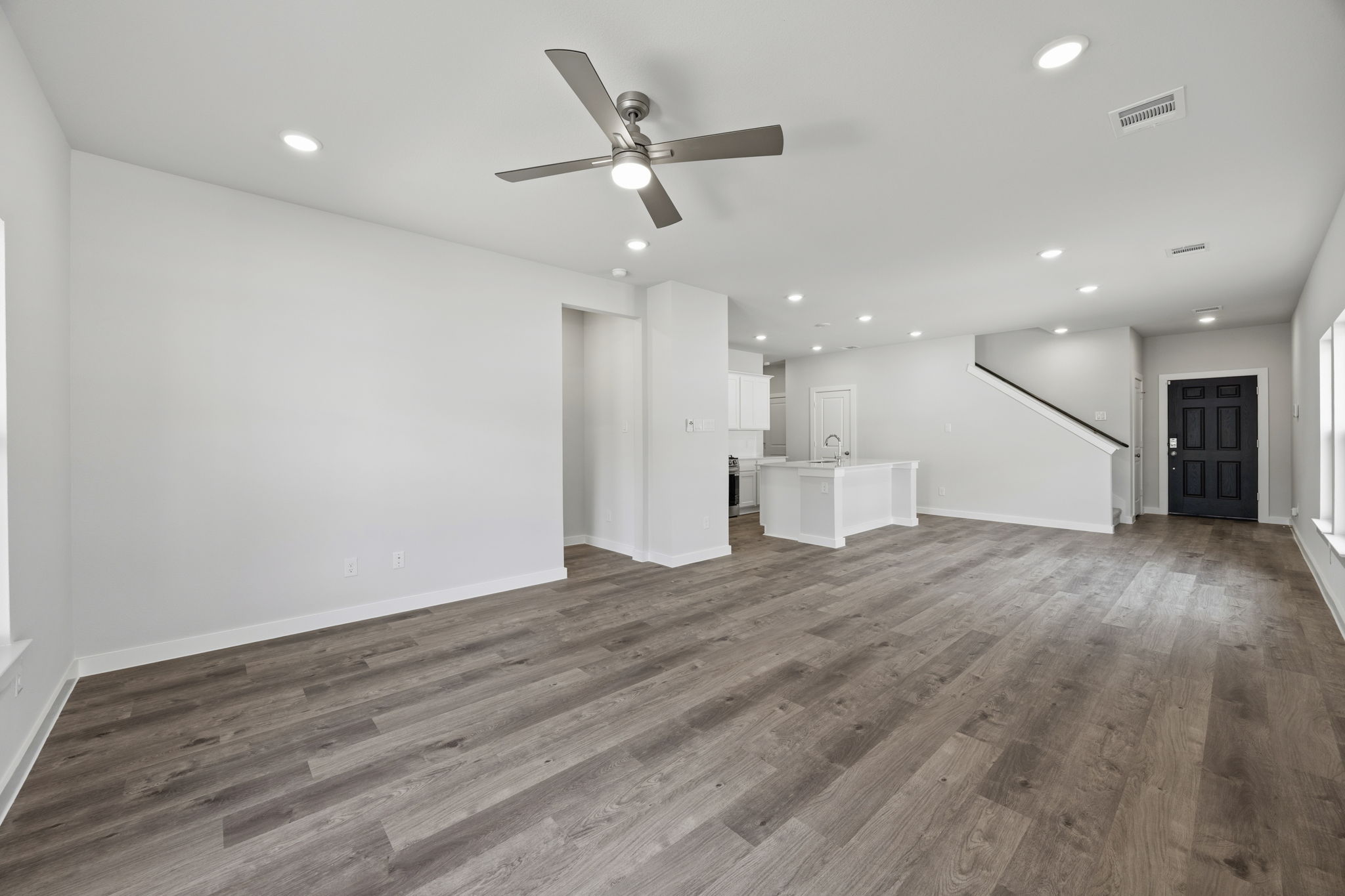 A room with a wood floor and a ceiling fan.