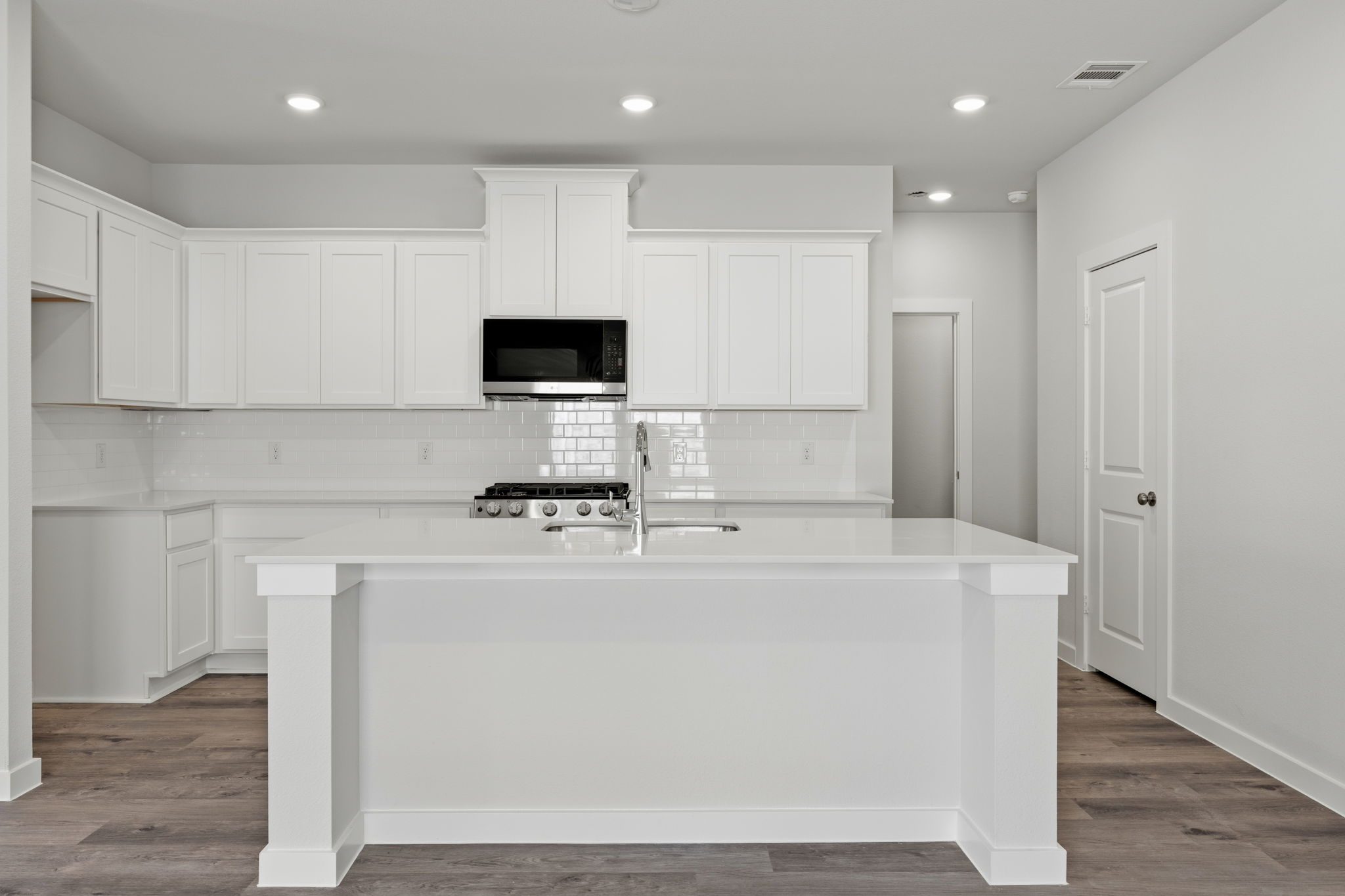 A kitchen with white cabinets.