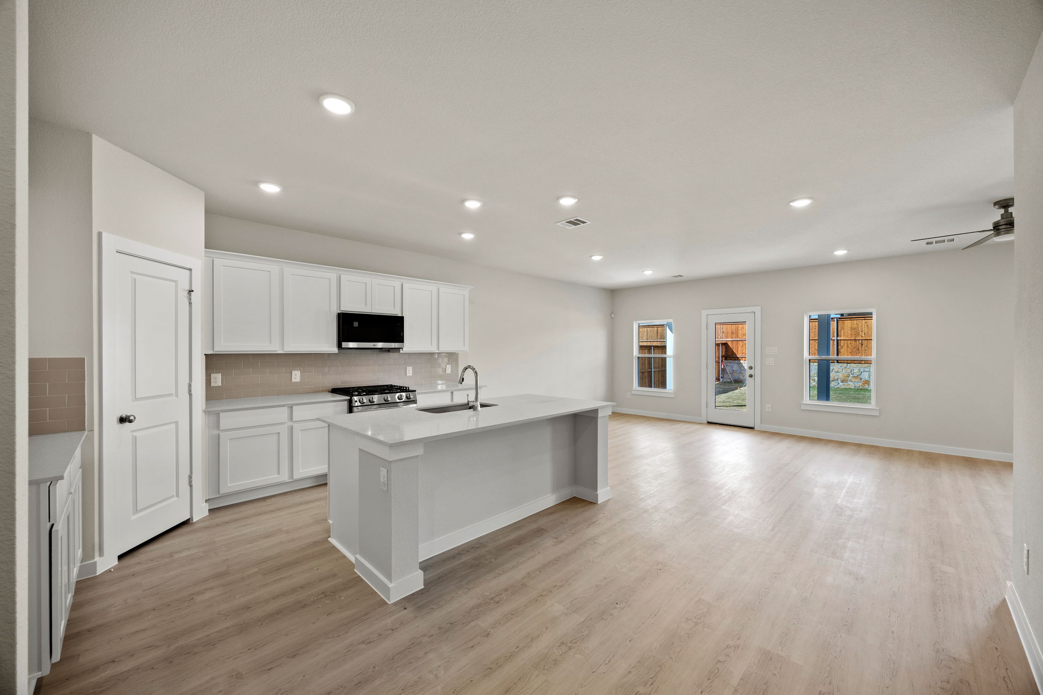 A kitchen with white cabinets.