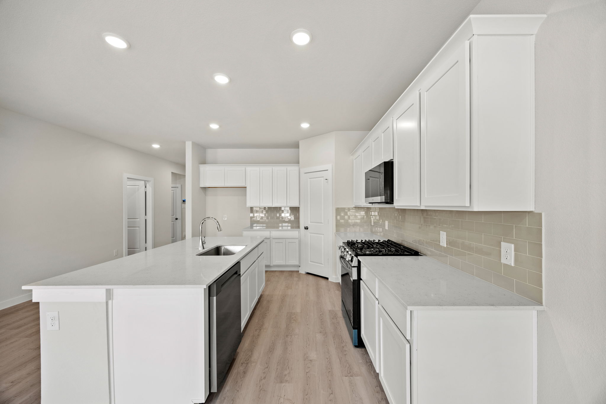 A kitchen with white cabinets.