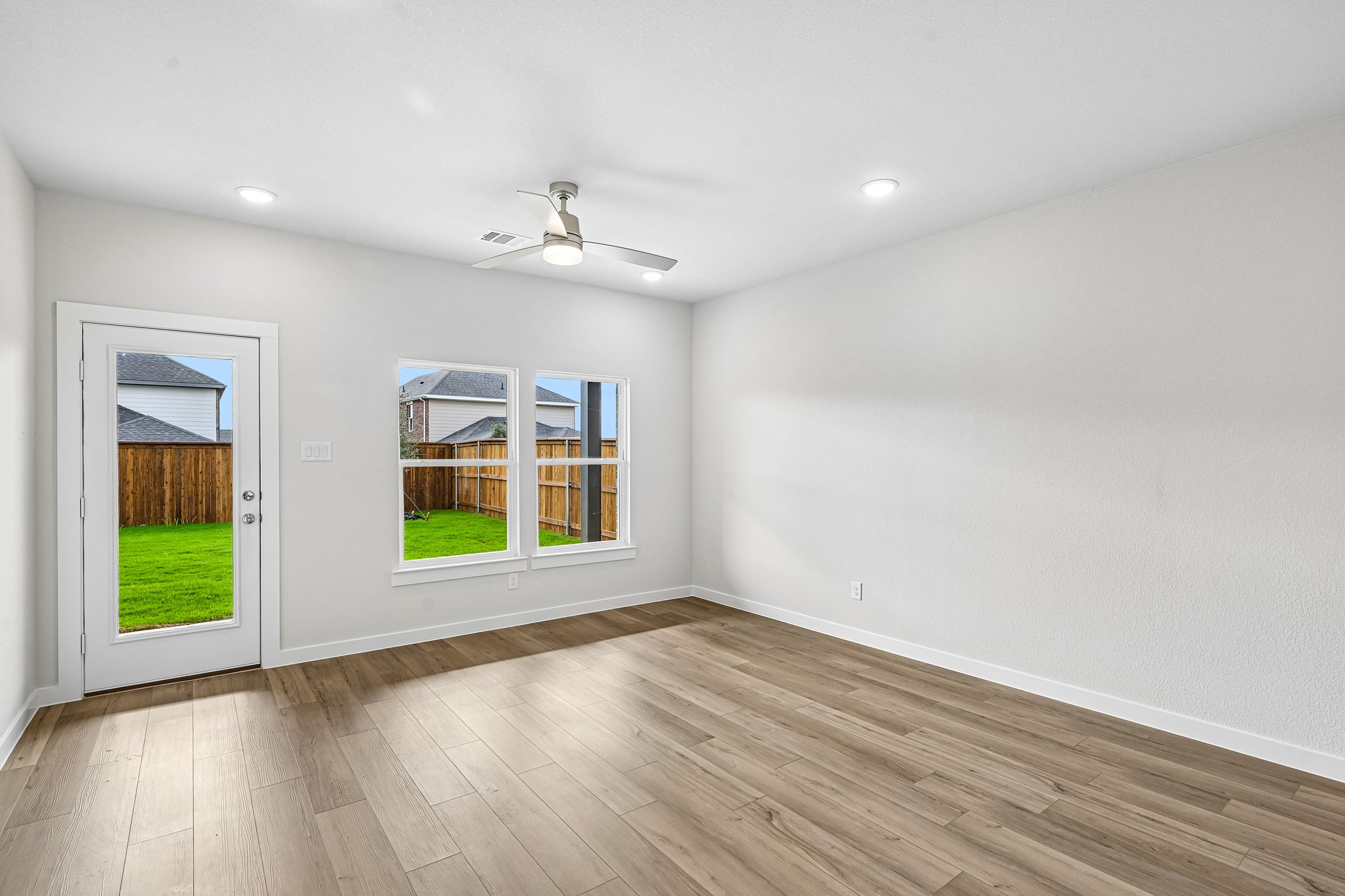 A room with a wood floor and a wood floor with a window.