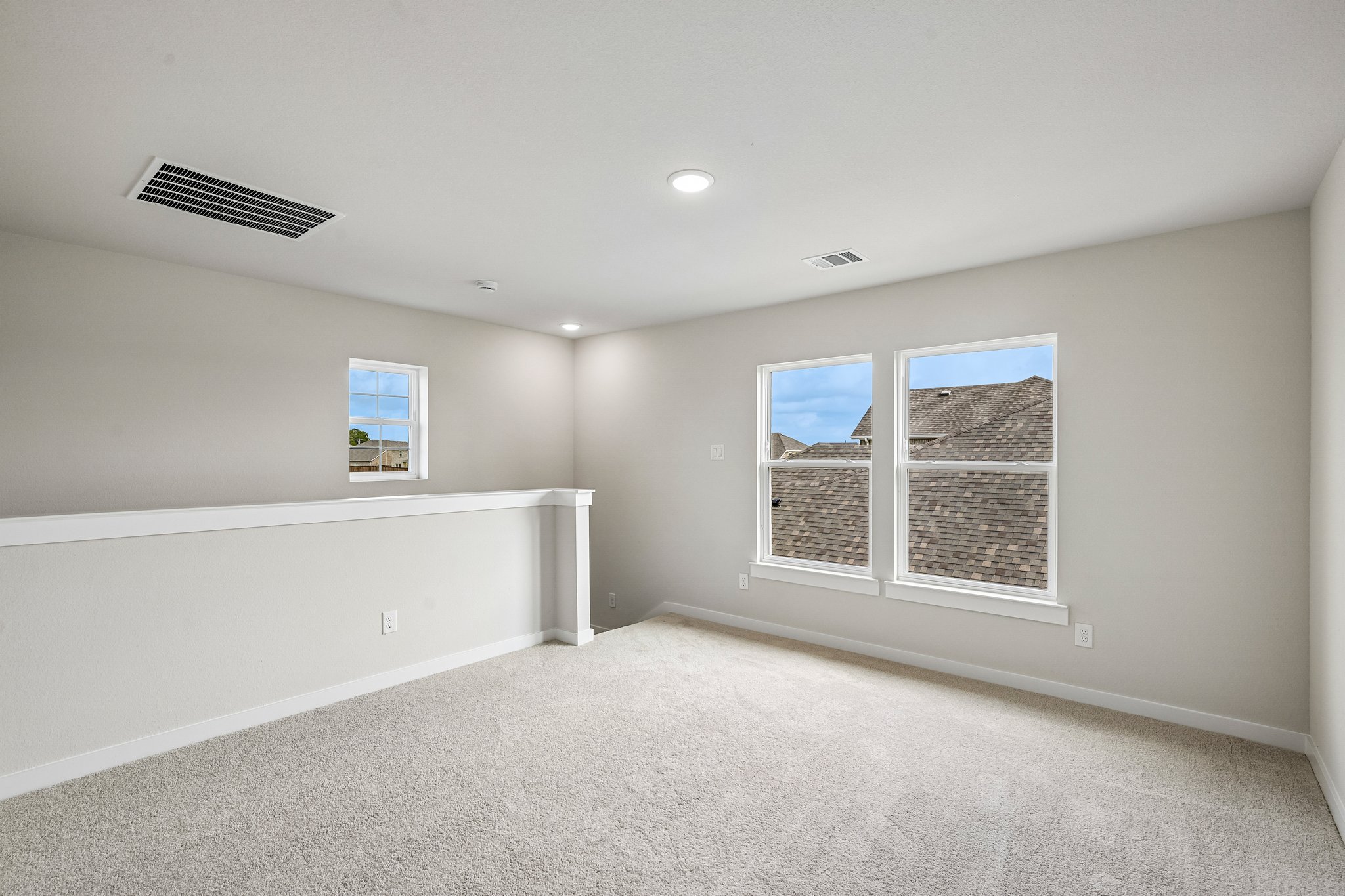 A room with a window and a white carpet.