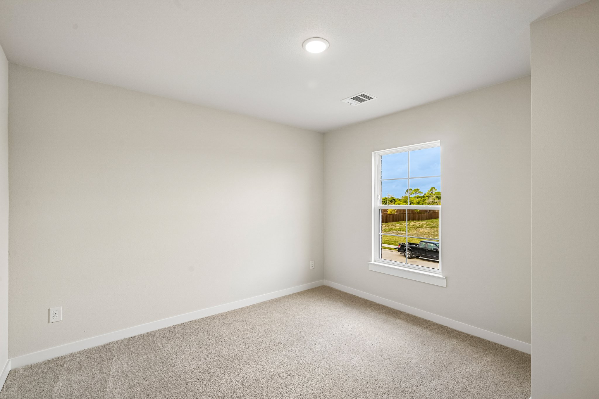 A room with a window and a carpet.