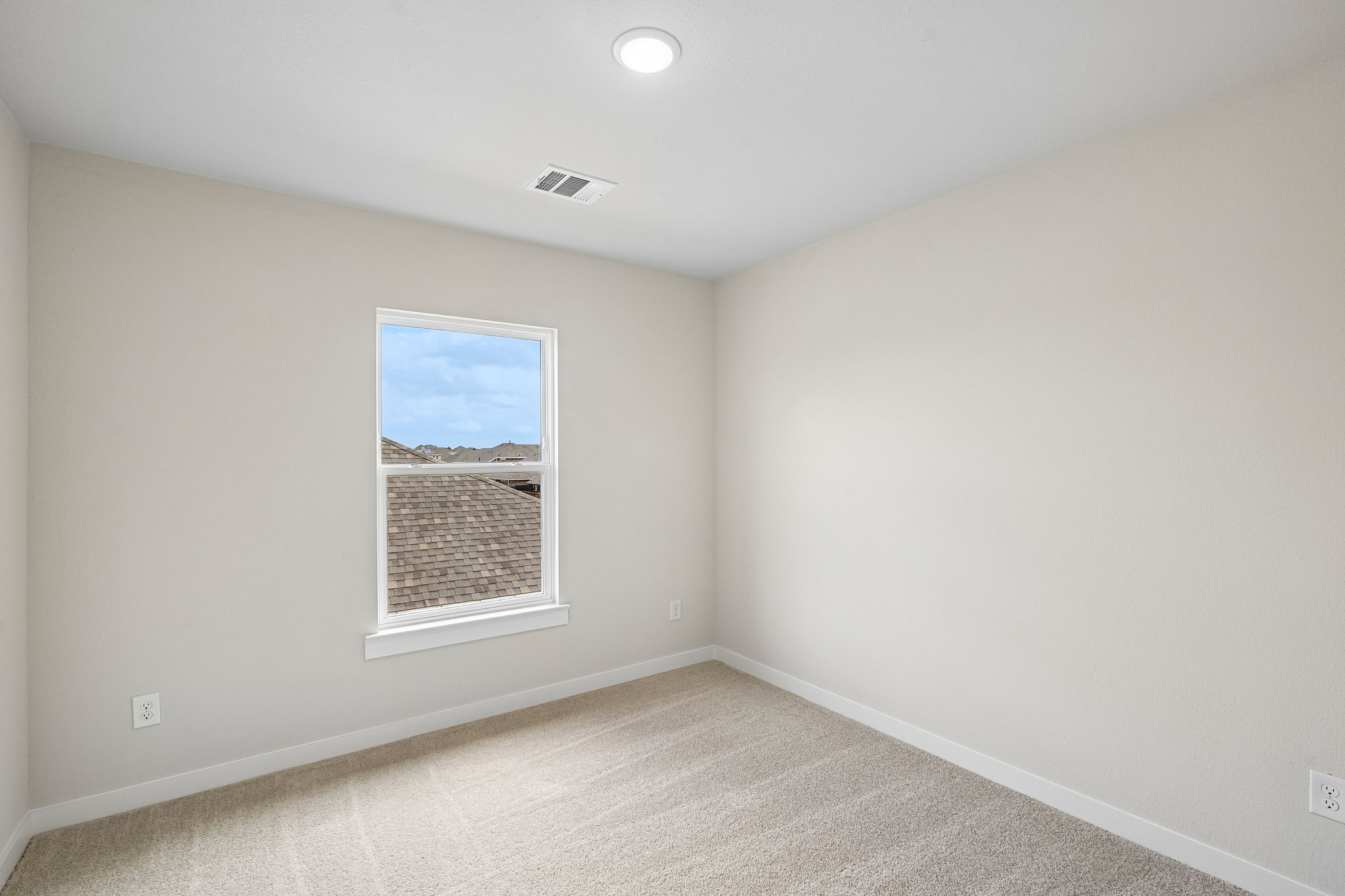 A room with a window and a carpet.