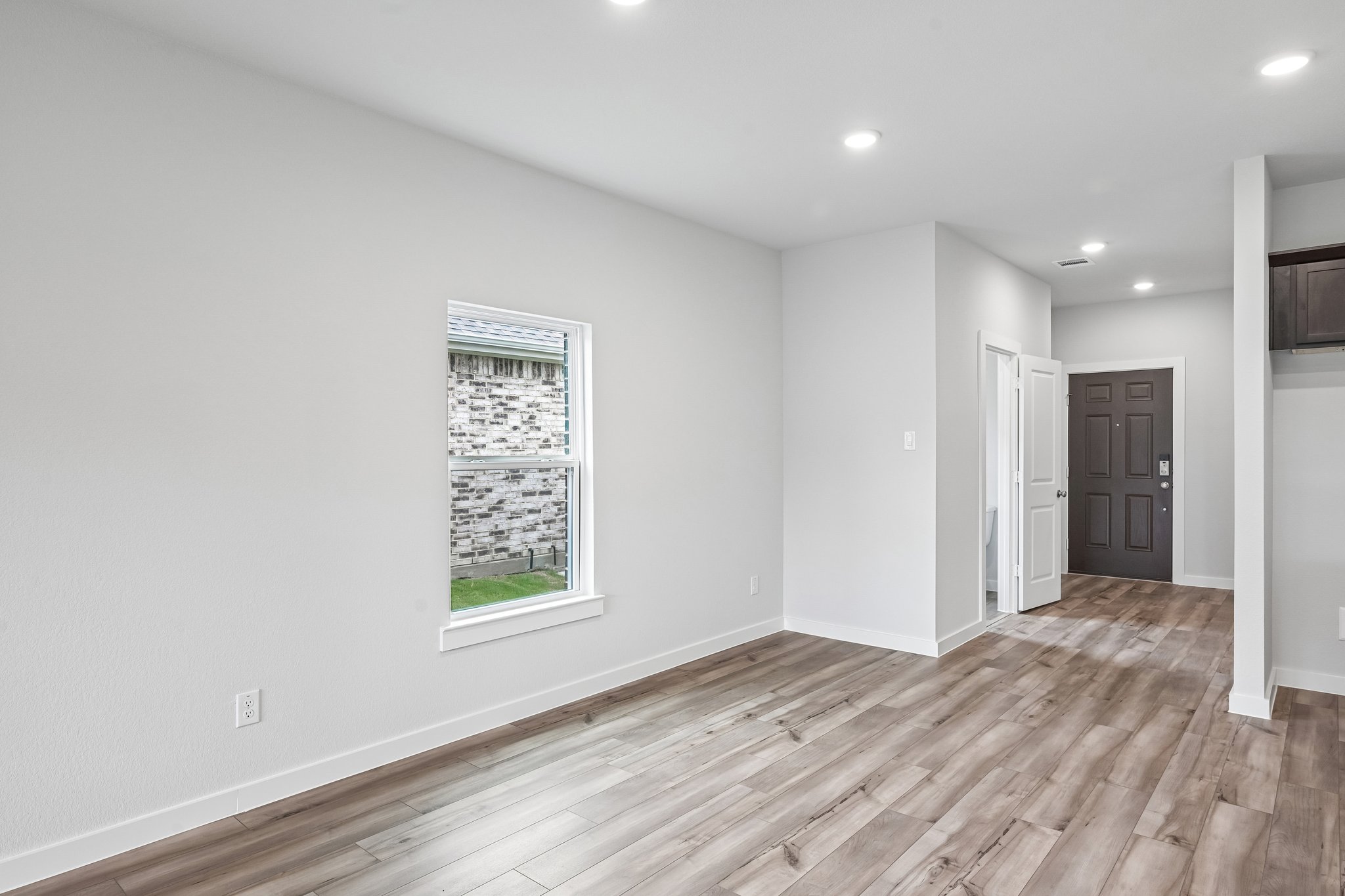 A room with a wood floor and a window.