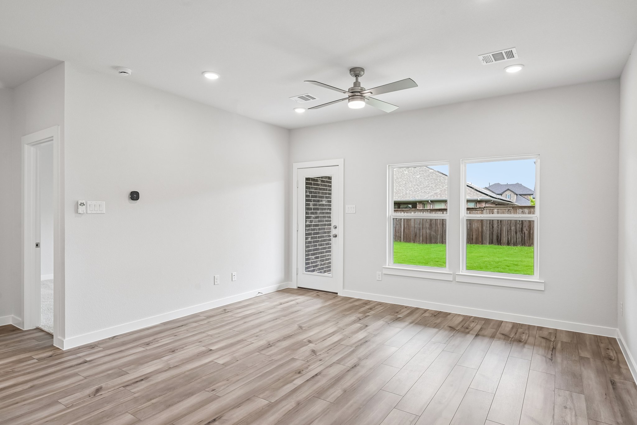 A room with a wood floor and a wood floor with a wood floor and a ceiling fan and.