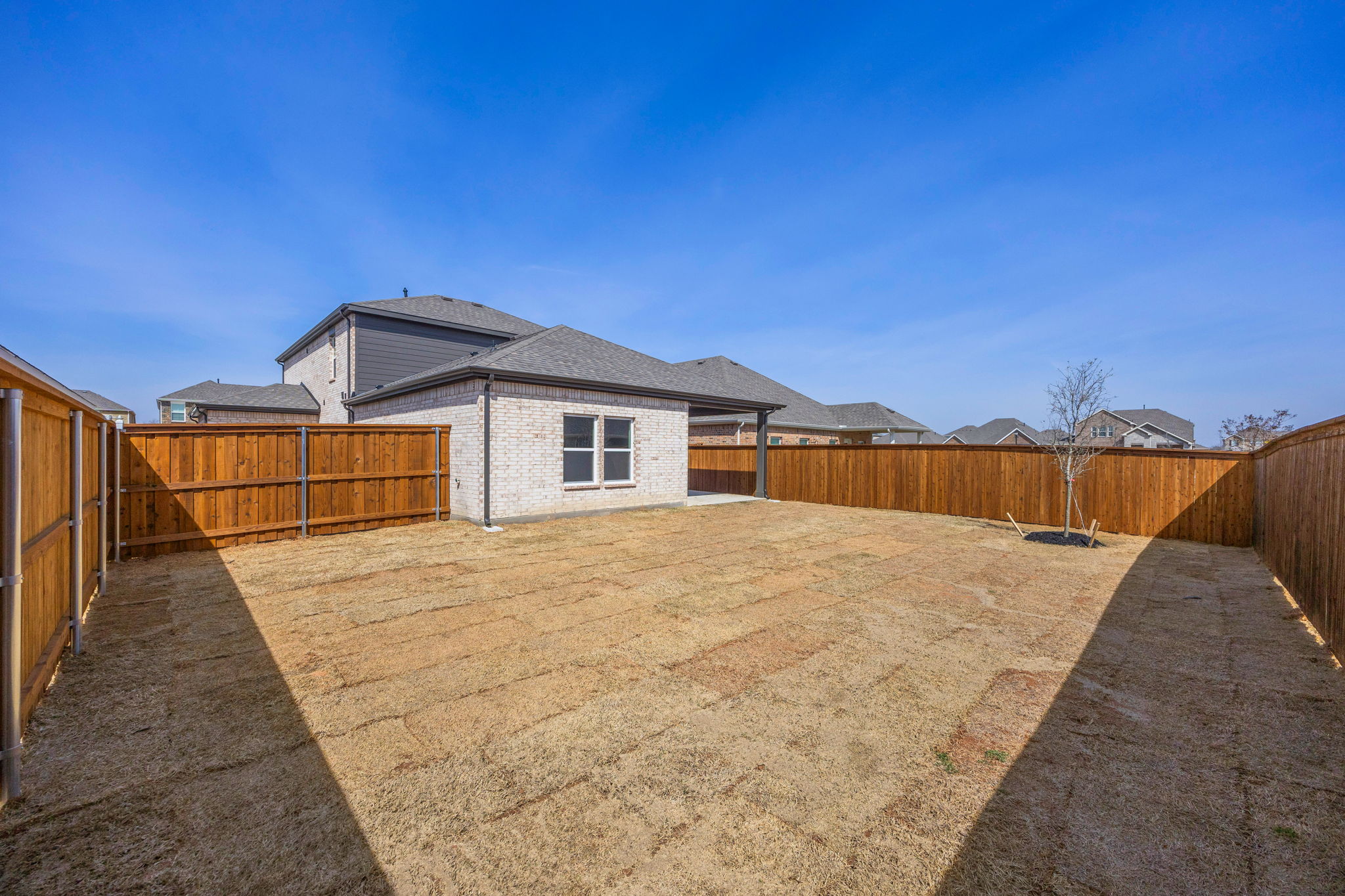 A fenced in dirt yard.